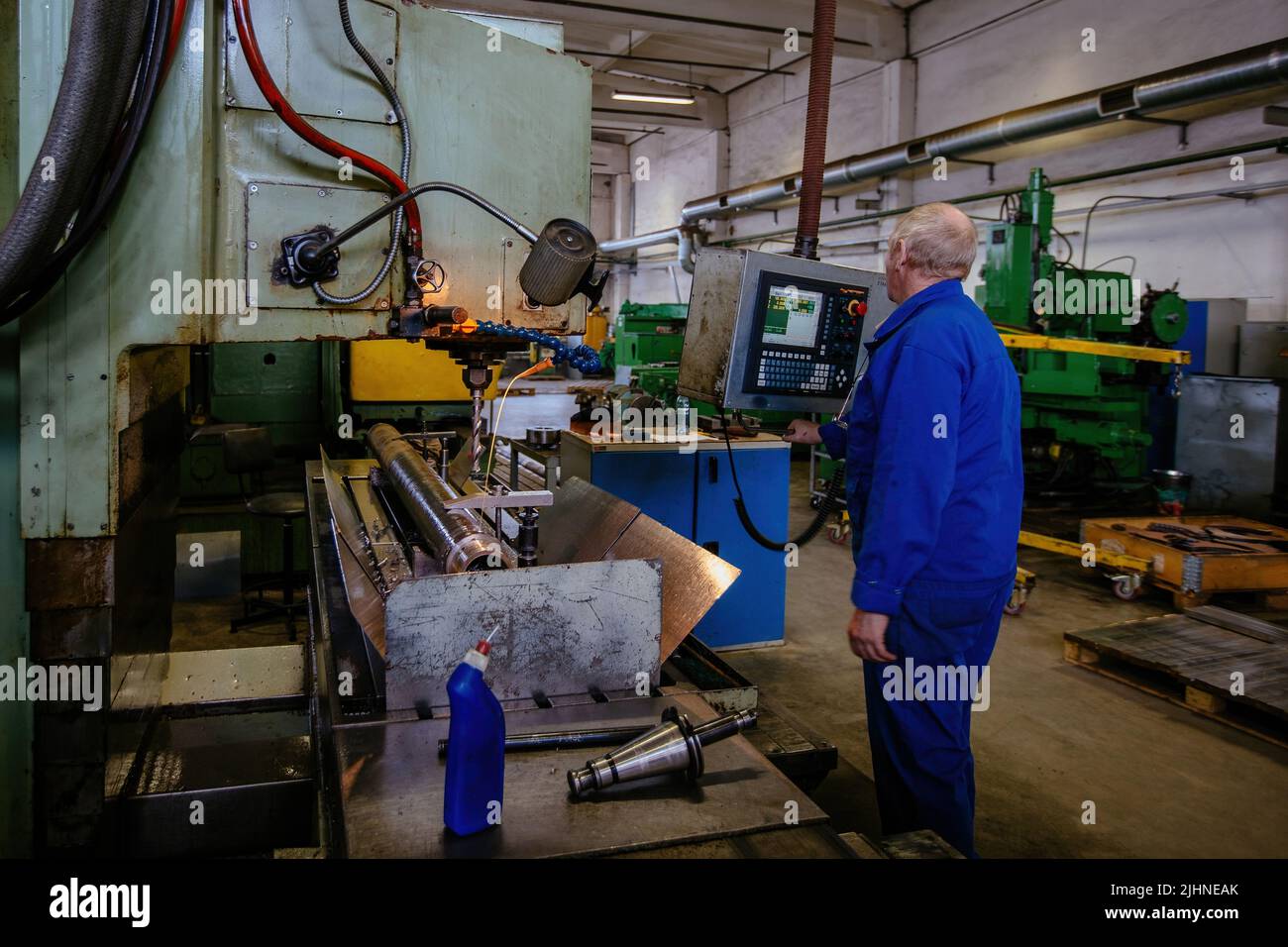 Factory engineer working on CNC drilling machine Stock Photo