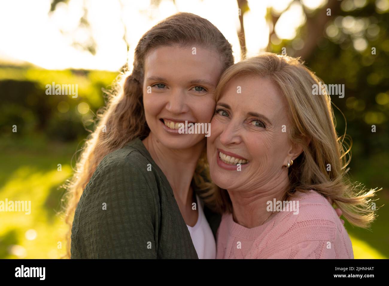 Image of happy caucasian mother and adult daughter posing at camera in autumn garden Stock Photo