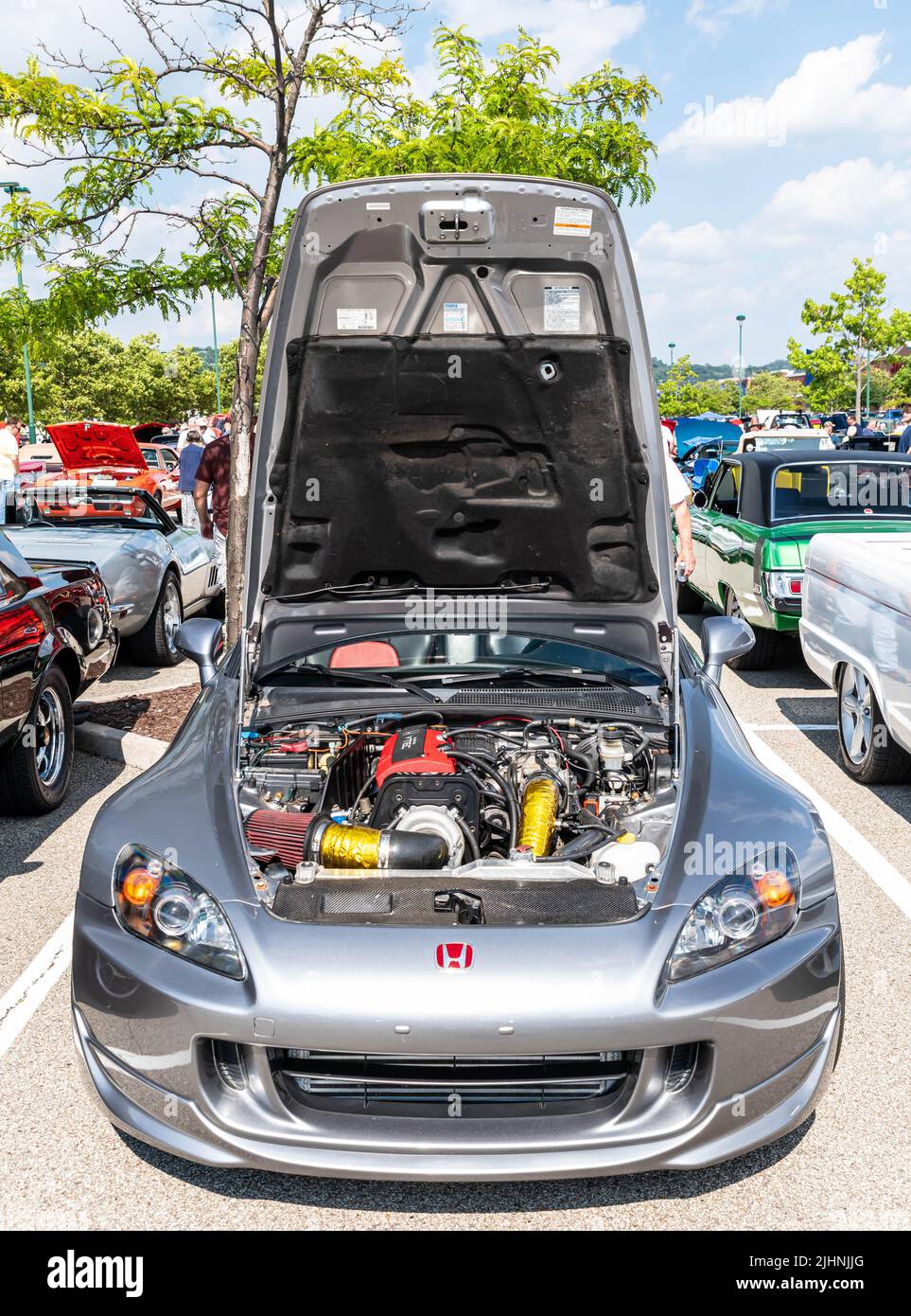 The engine compartment and motor of a silver Honda coupe at the