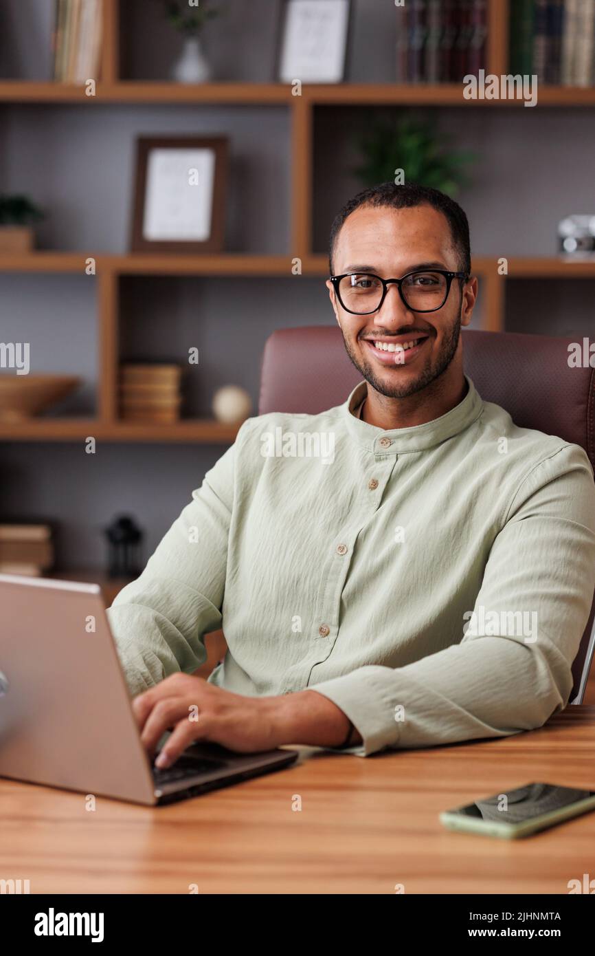Portrait of young african ameriran businessman working with laptop at ...