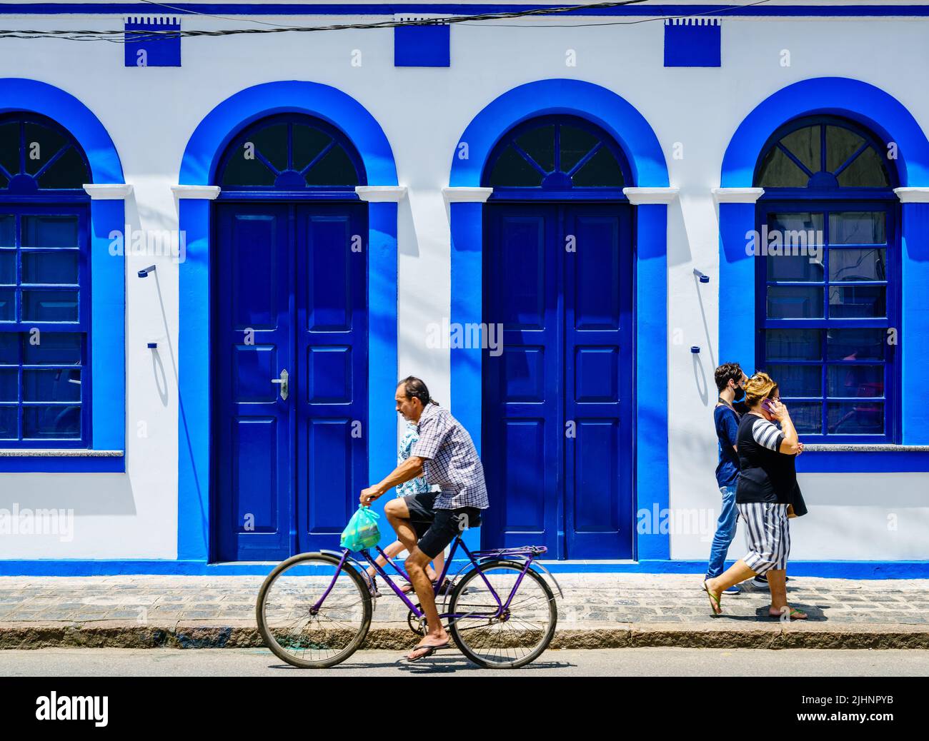 Morretes, Brazil, January 21, 2022: people are passing by a colorful house facade in historic town of Morretes, Brazil Stock Photo