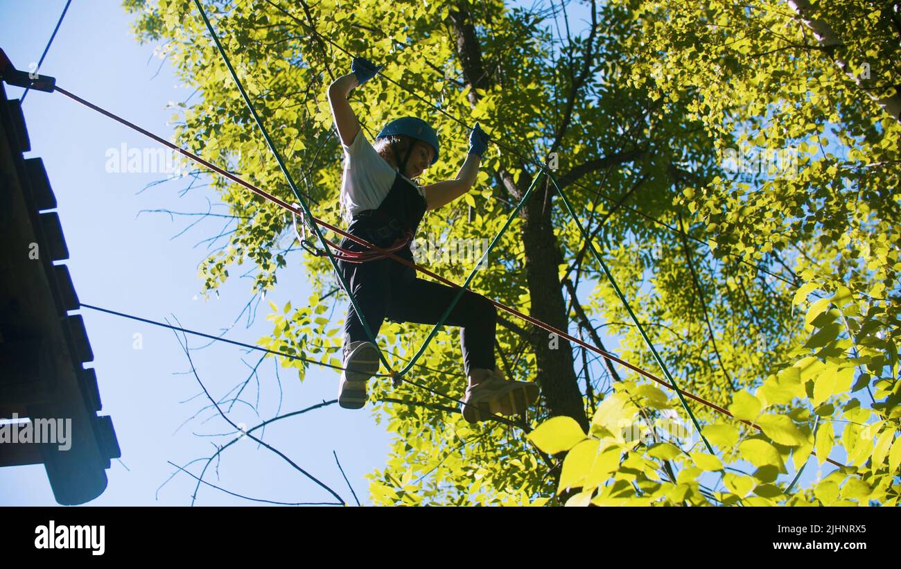 Rope adventure in forest woman stands on ropes Stock Photo Alamy