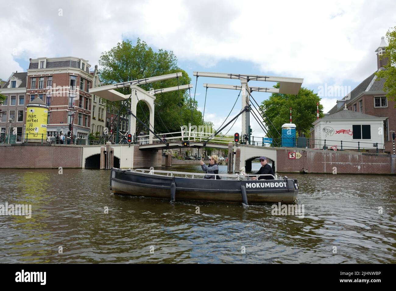 Small boat on the Amstel river in front of a drawbridge in Amsterdam Stock Photo