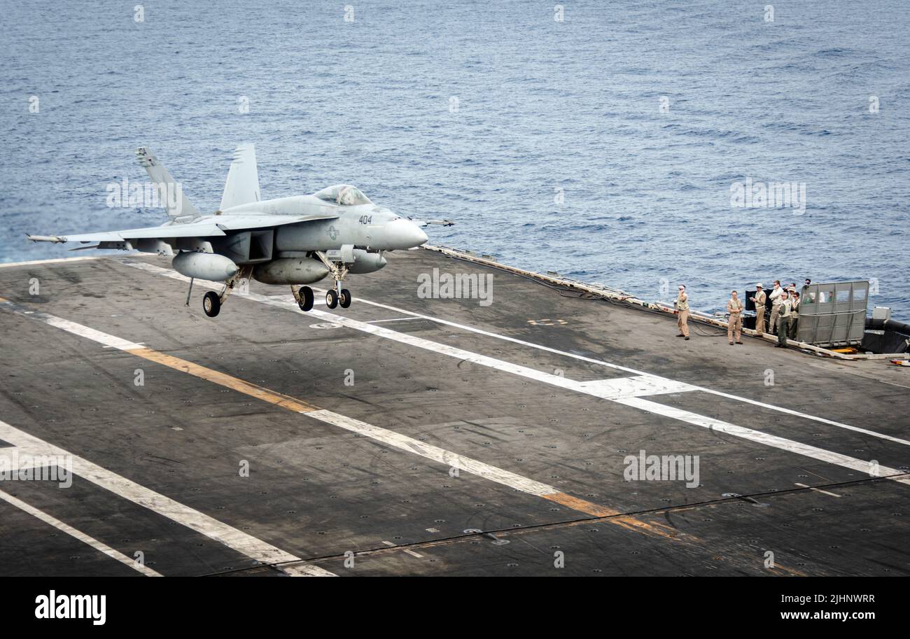 220717-N-WI365-1102 SOUTH CHINA SEA (July 17, 2022) An F/A-18E Super Hornet attached to the Dambusters of Strike Fighter Squadron (VFA) 195 lands on the flight deck of the Navy's only forward-deployed aircraft carrier USS Ronald Reagan (CVN 76). The Dambusters earned their nickname on May 1, 1951 when the squadron's Skyraiders destroyed the heavily defended and strategically positioned Hwacheon Dam in North Korea with aerial torpedoes by making precise low level runs. Ronald Reagan, the flagship of Carrier Strike Group 5, provides a combat-ready force that protects and defends the United State Stock Photo