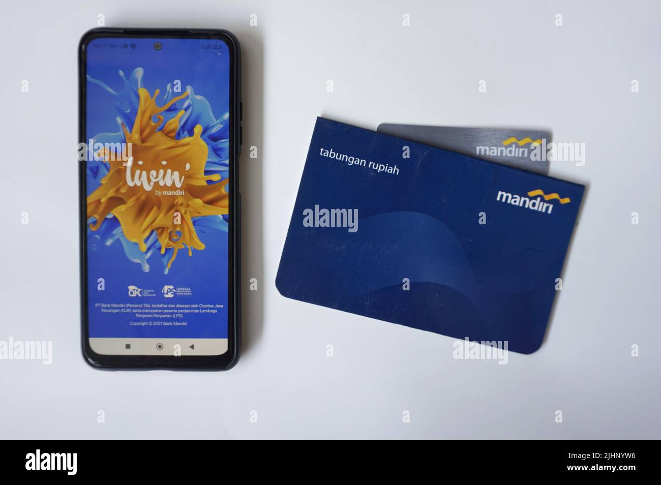 Yogyakarta, Indonesia - July 10th, 2022. Pictures of Bank Mandiri accounts book, ATM Card and mobile banking on a smartphone called Mandiri Livin'. Stock Photo
