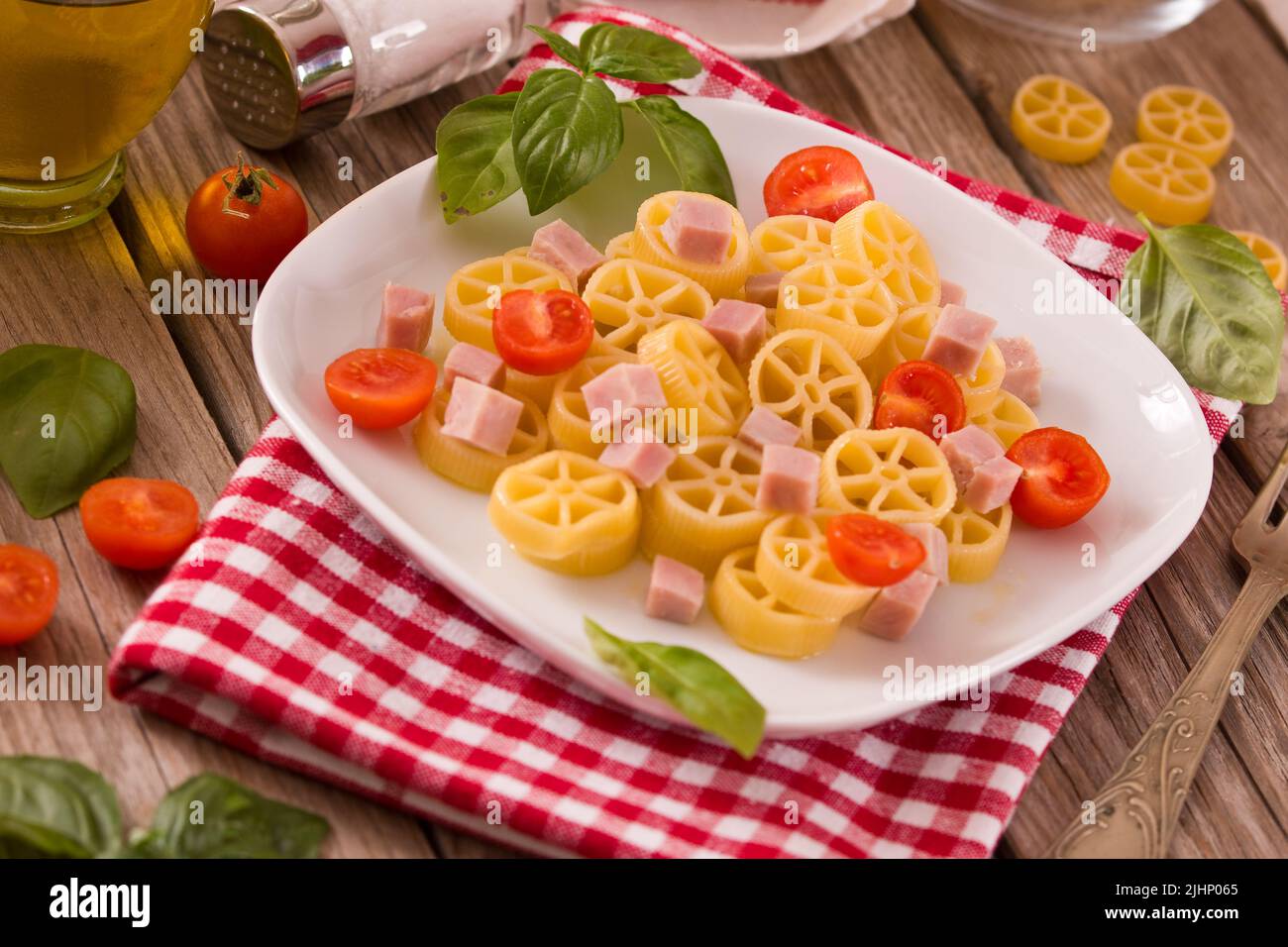 Ruote pasta with tomato and ham. Stock Photo