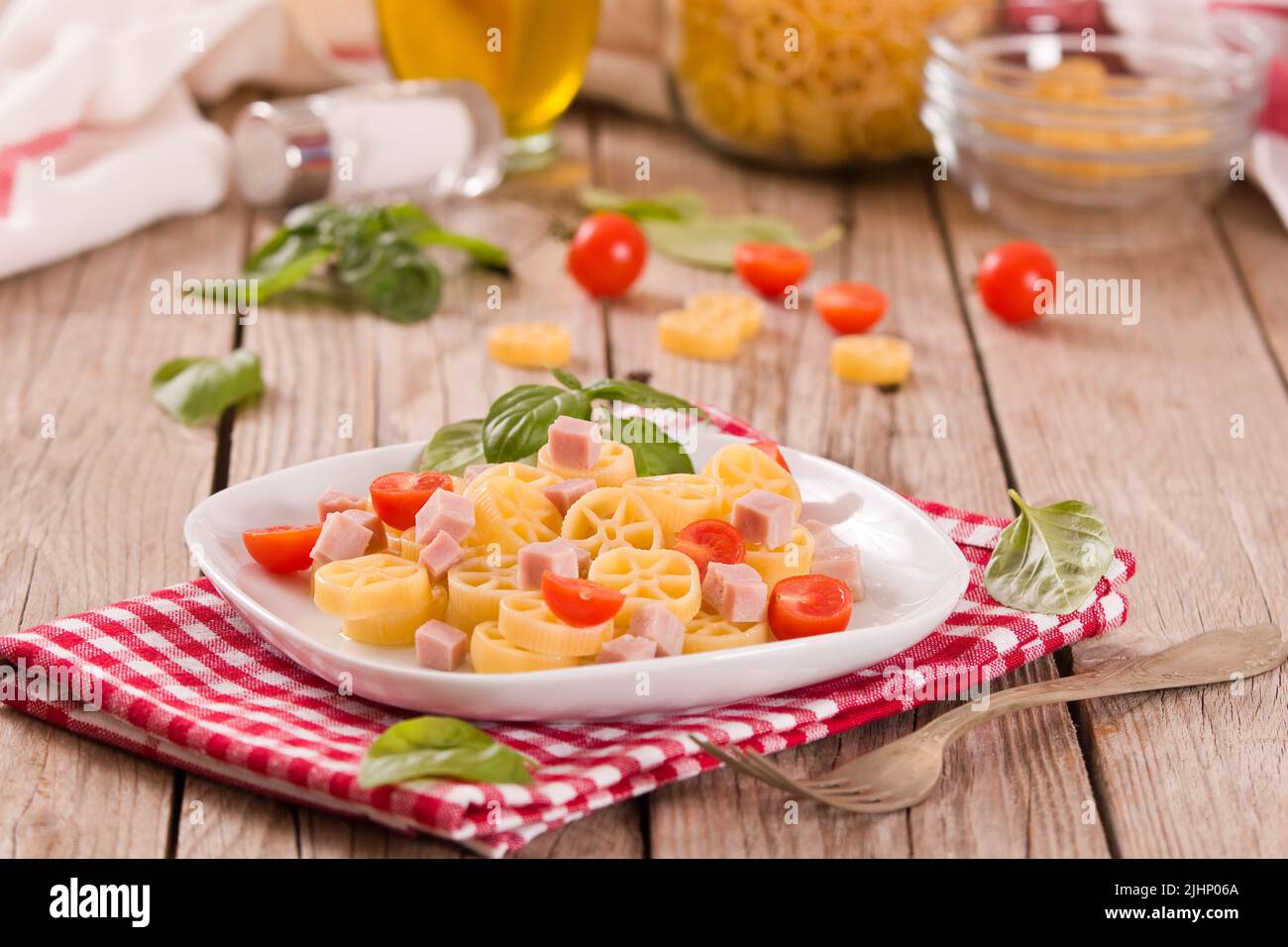 Ruote pasta with tomato and ham. Stock Photo