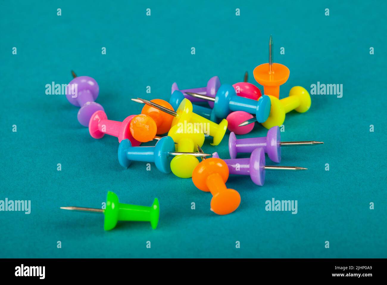 Colourful thumbtack pins on a blue background Stock Photo