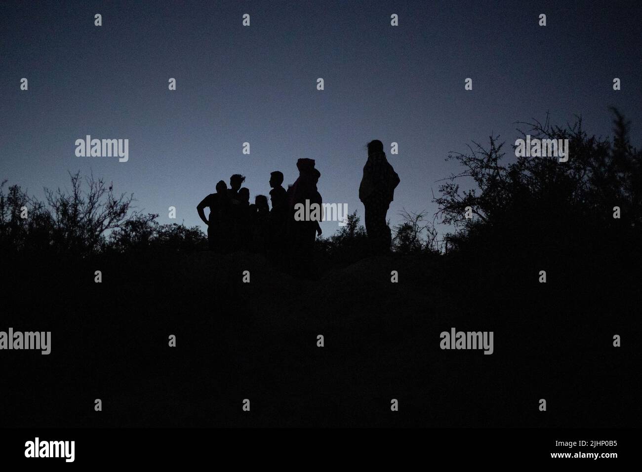 Migrants from Central and South America pause to find their way after crossing the Rio Grande river into the United States from Mexico in Roma, Texas, U.S., July 18, 2022. REUTERS/Adrees Latif Stock Photo