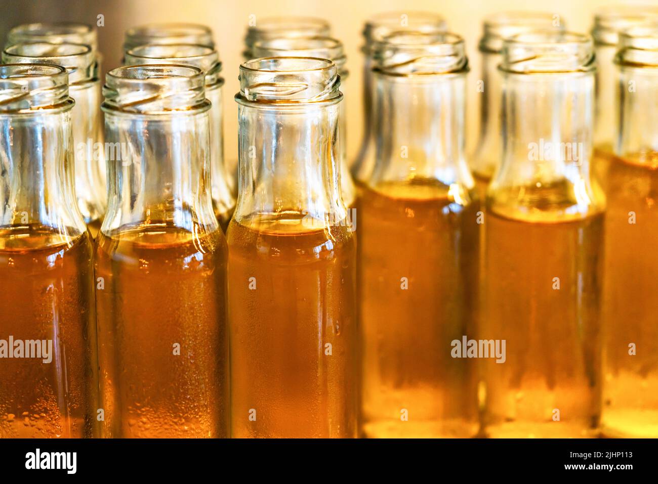 Close up small bottle glass of fresh Chrysanthemum tea, group of cold Chrysanthemum tea in cleared bottles, water drops on bottles, warm light. Stock Photo