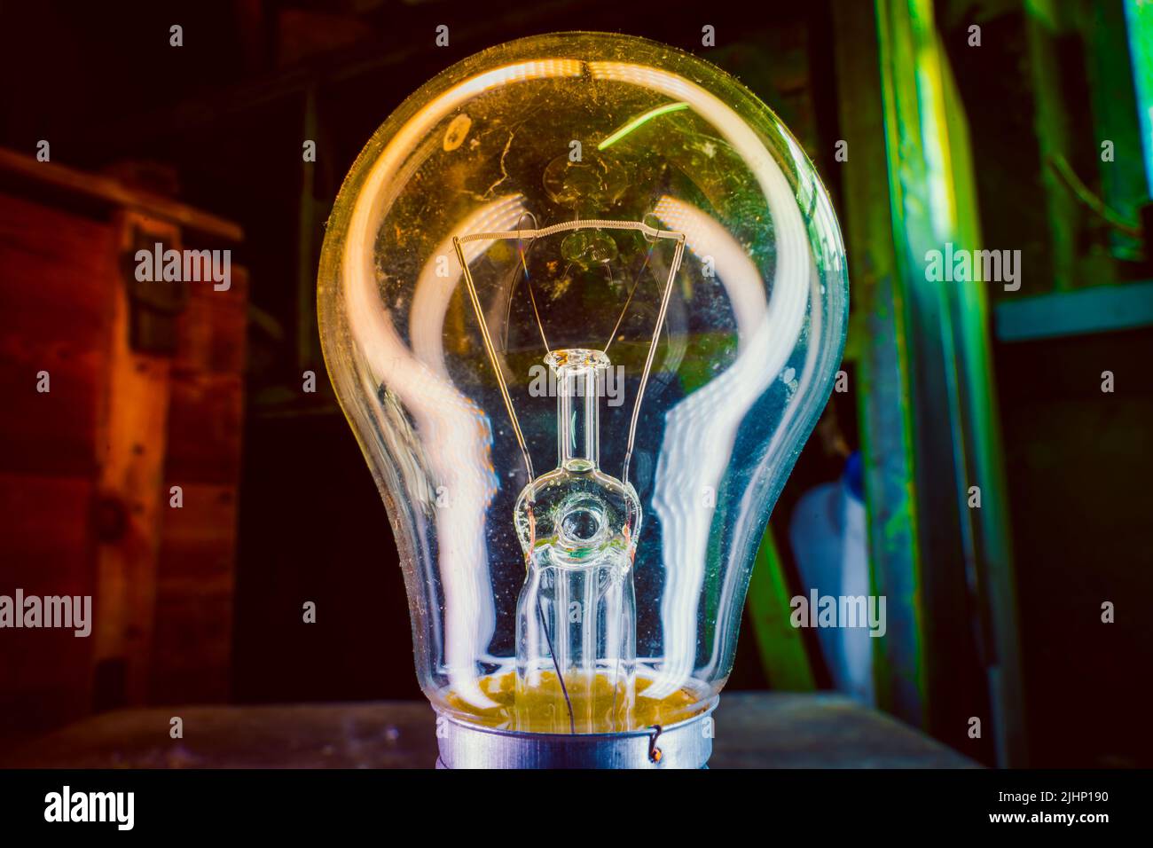 Old incandescent light bulb closeup on colorful lighting Stock Photo