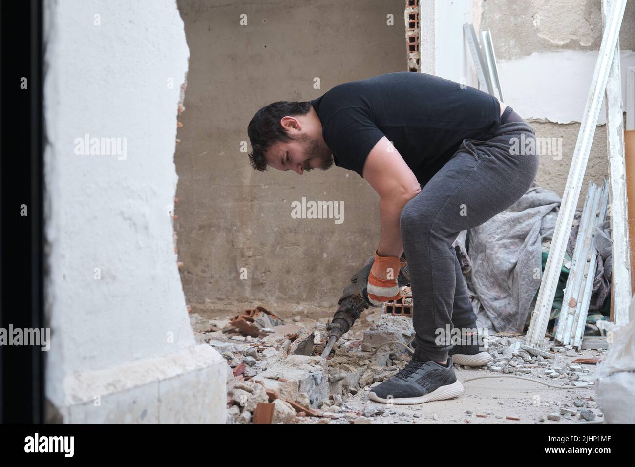 Handyman using a jackhammer to drill into wall Stock Photo Alamy