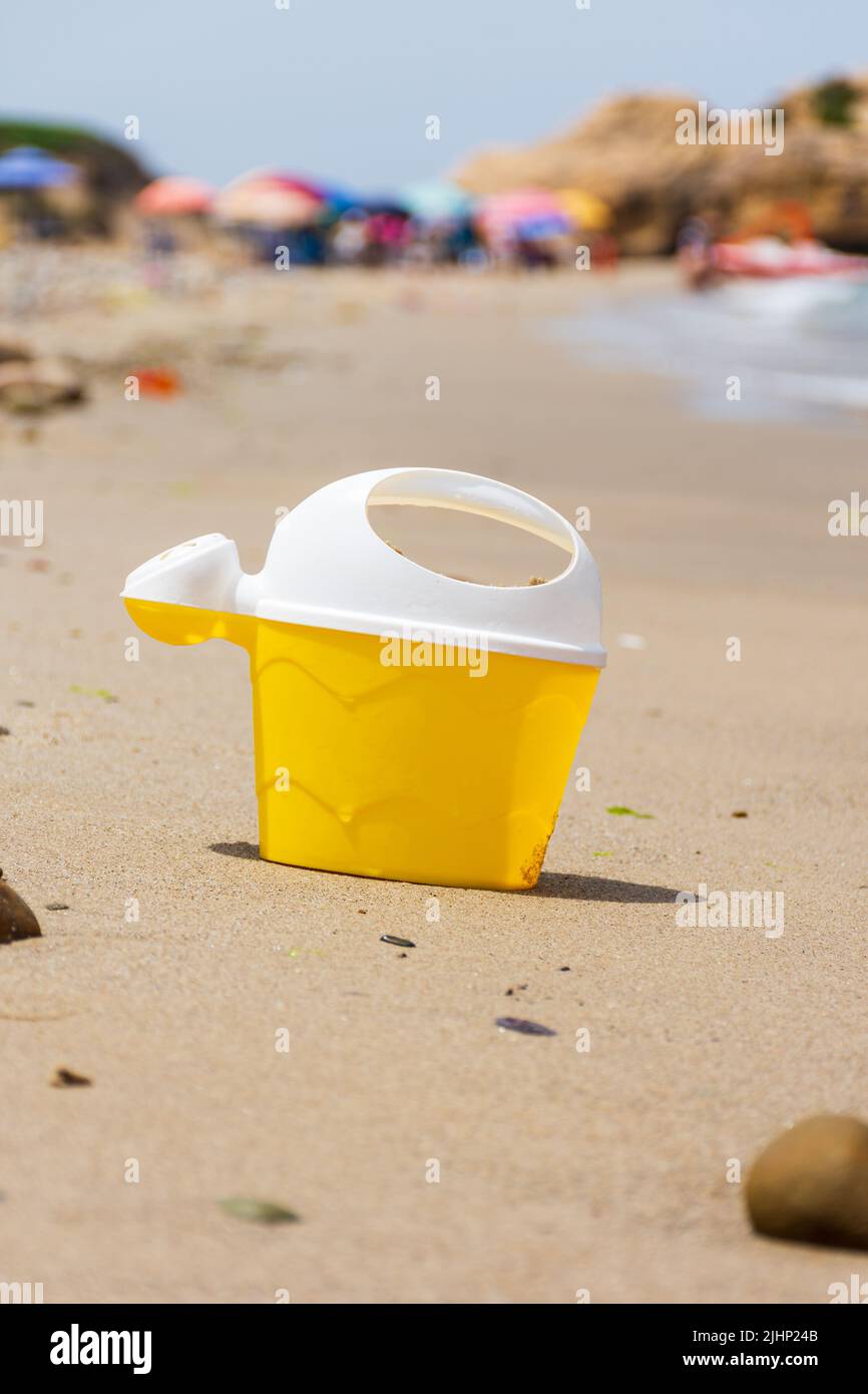 Close up a yellow kid's plastic toy bucket on the beach. Stock Photo