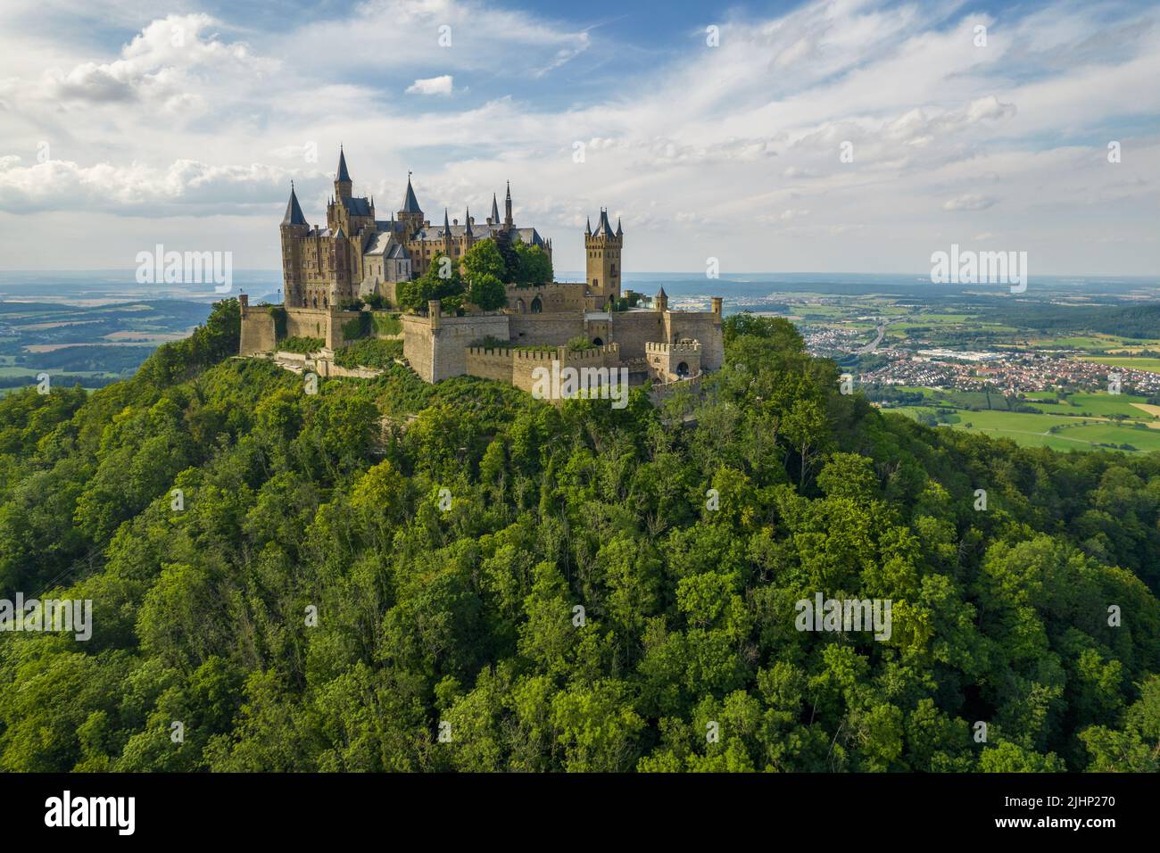 Drone Shot Of Hohenzollern Castle On Forested Mountain Top In The drone-shot-of-hohenzollern-castle-on-forested-mountain-top-in-the