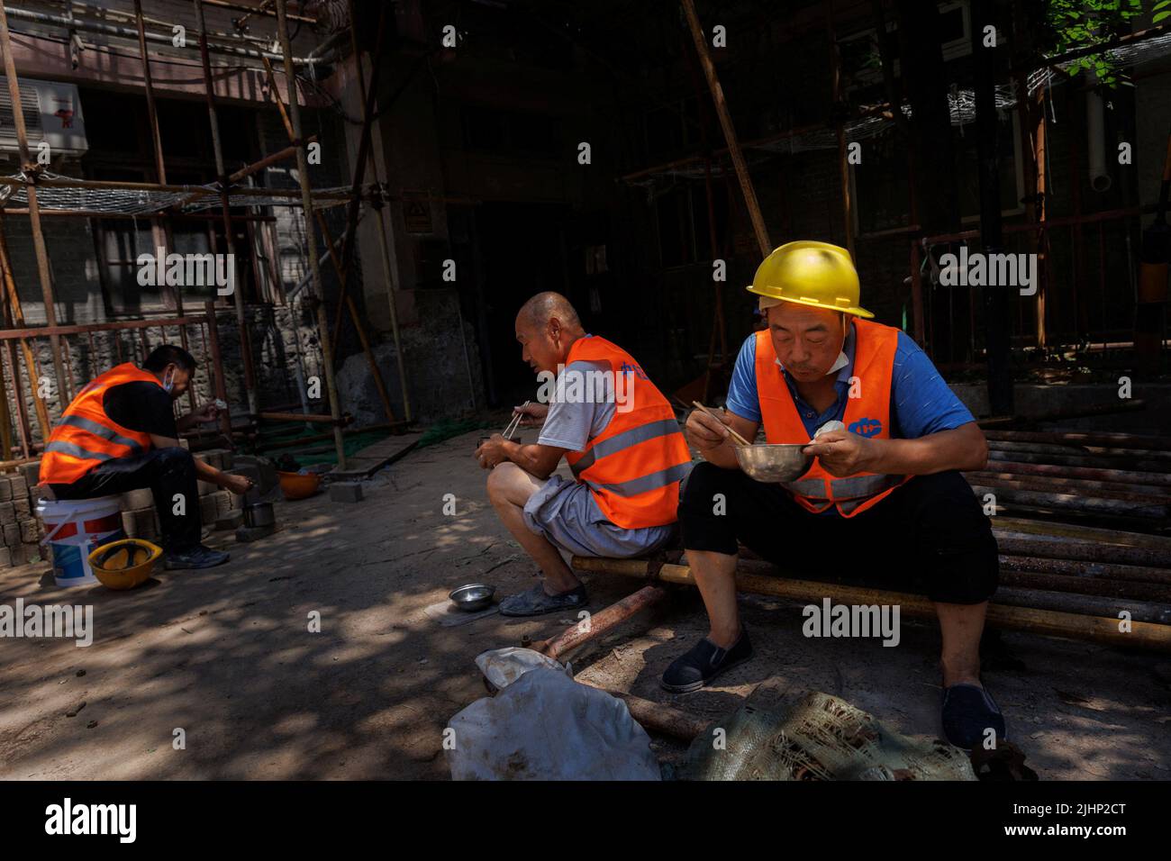 Workers eat lunch at a construction site in Beijing, China, July 20, 2022. REUTERS/Thomas Peter Stock Photo