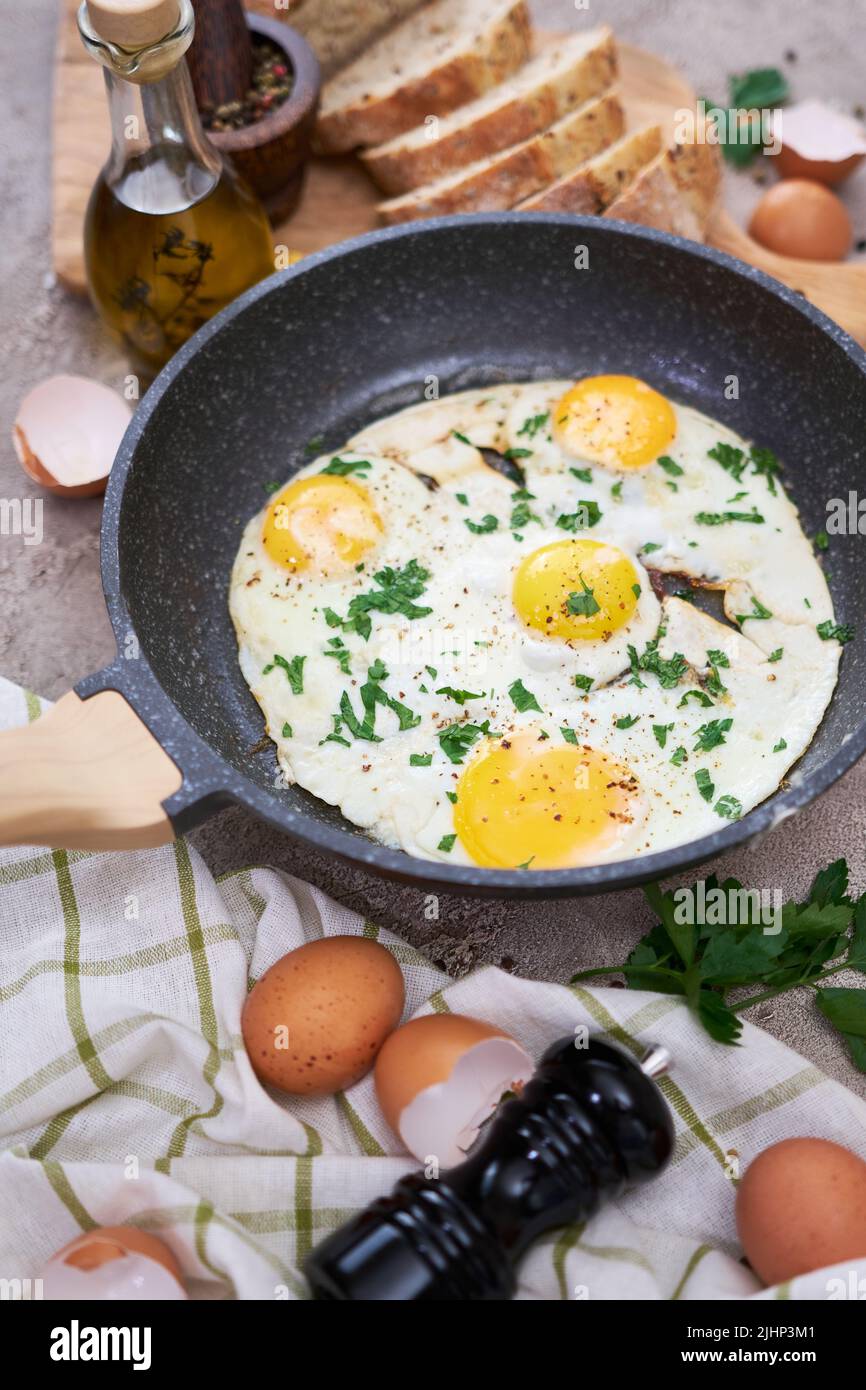 Fried Egg in cast iron frying pan on black induction hob Stock Photo
