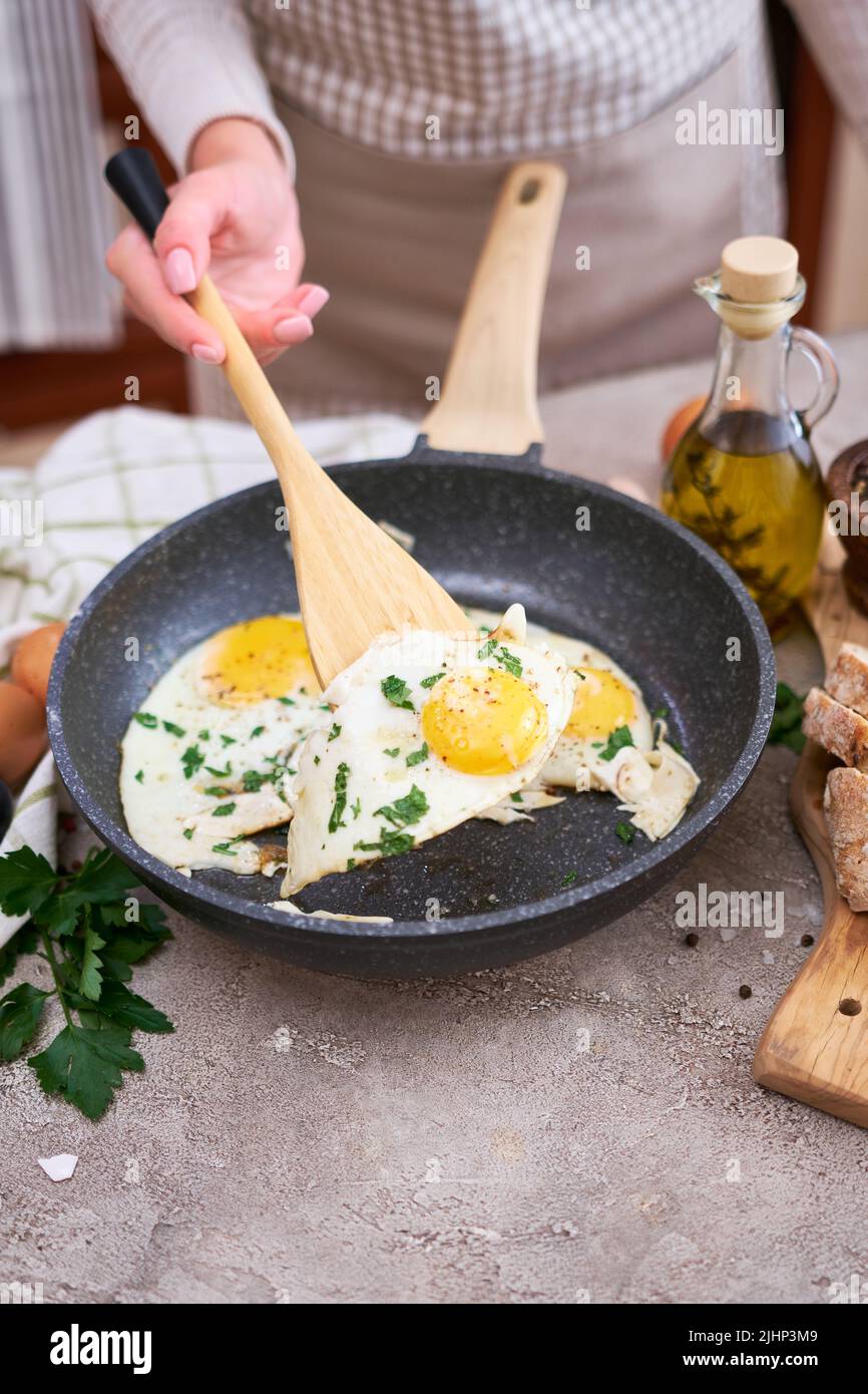 Fried Egg in cast iron frying pan on black induction hob Stock Photo