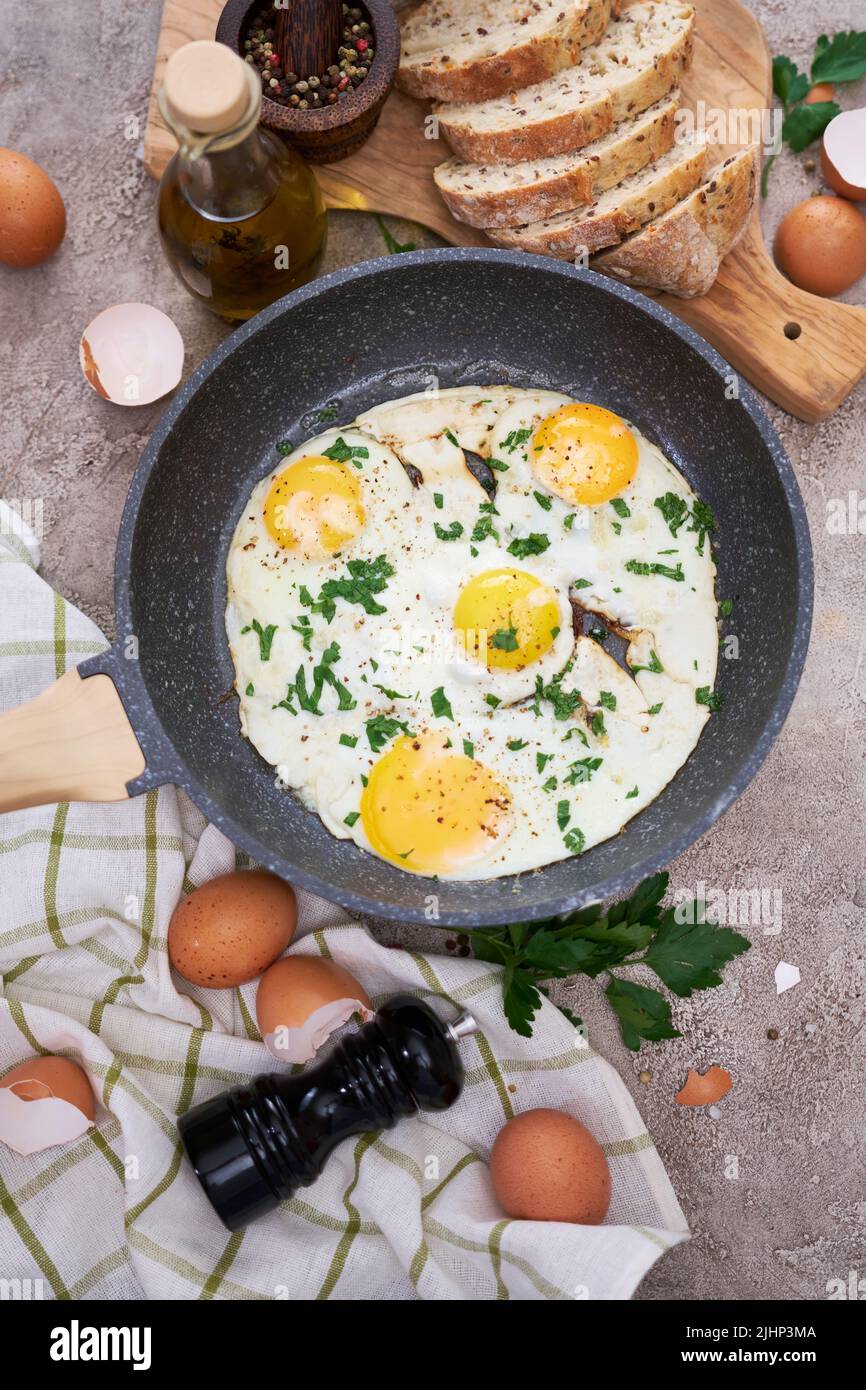 Fried Egg in cast iron frying pan on black induction hob Stock Photo