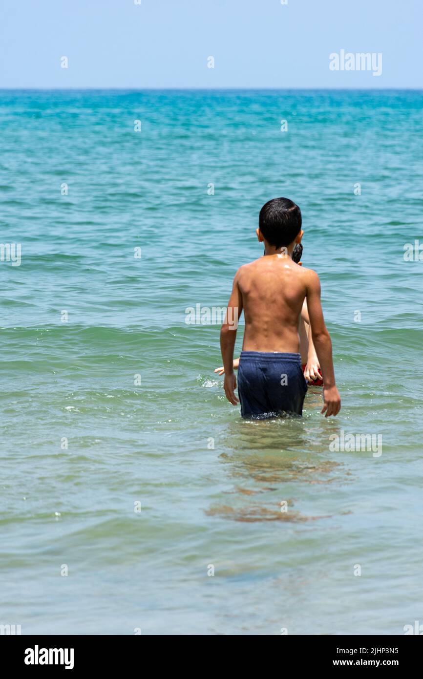 View of young boys playing in the  Mediterranean sea. Summer vacation concept. Stock Photo
