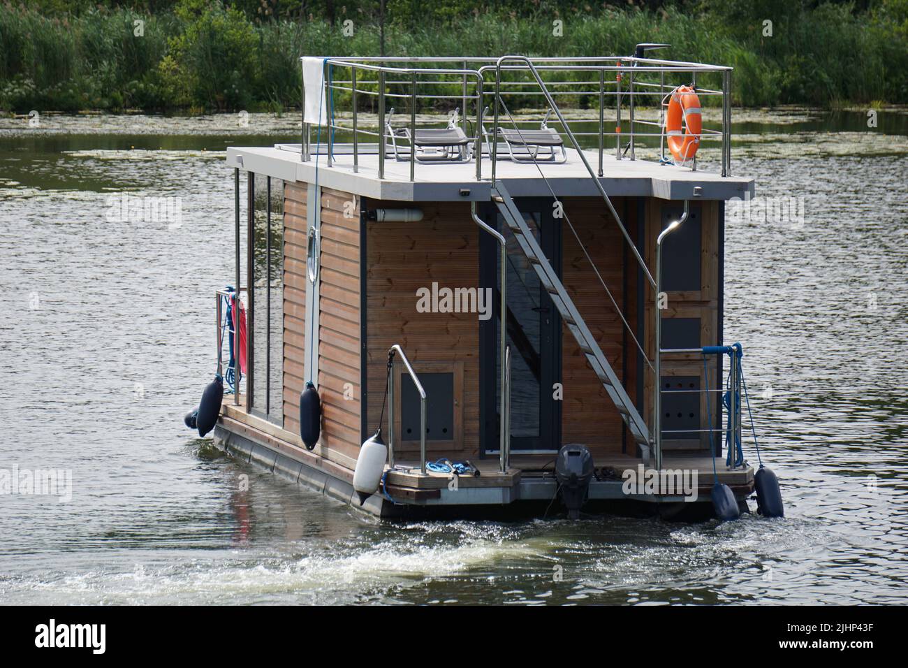 Modern house boat swimming on lake Stock Photo