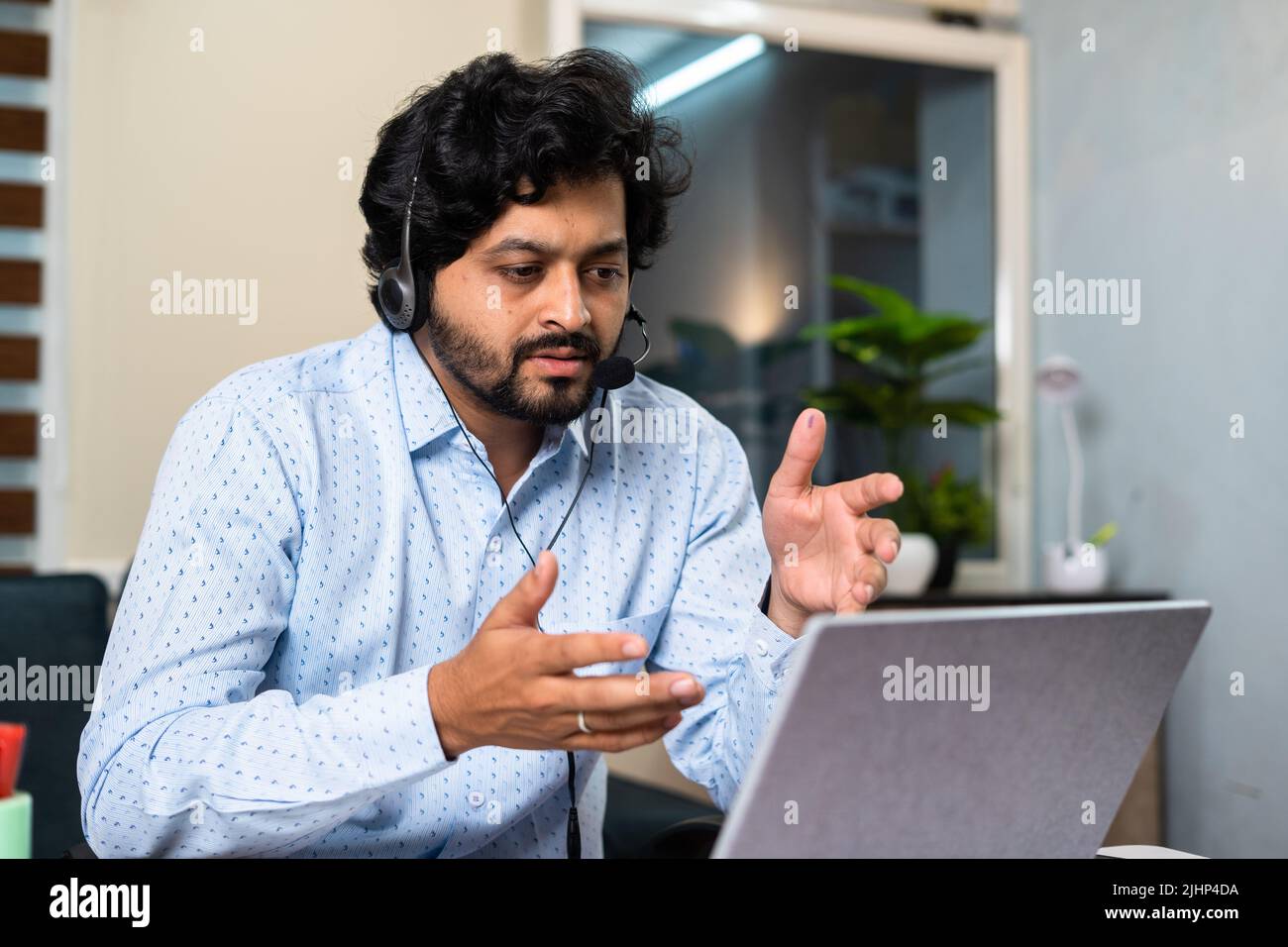 Corporate employee busy attanding meeting by advising on laptop at office - concept of customer service, client support and communication skills. Stock Photo