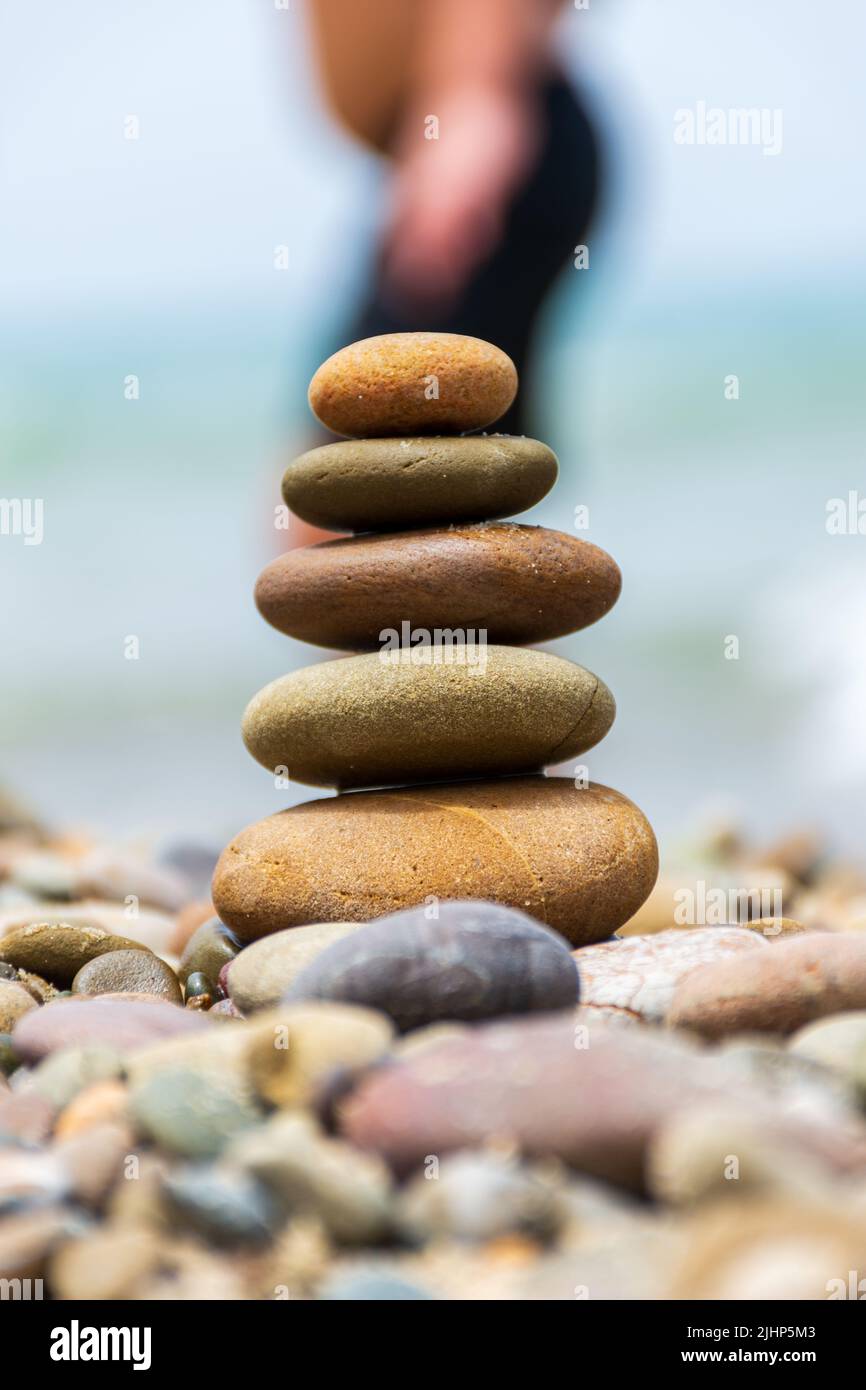 Close-up pyramid stones balance on the beach. Calm. Zen-like concept. Stock Photo
