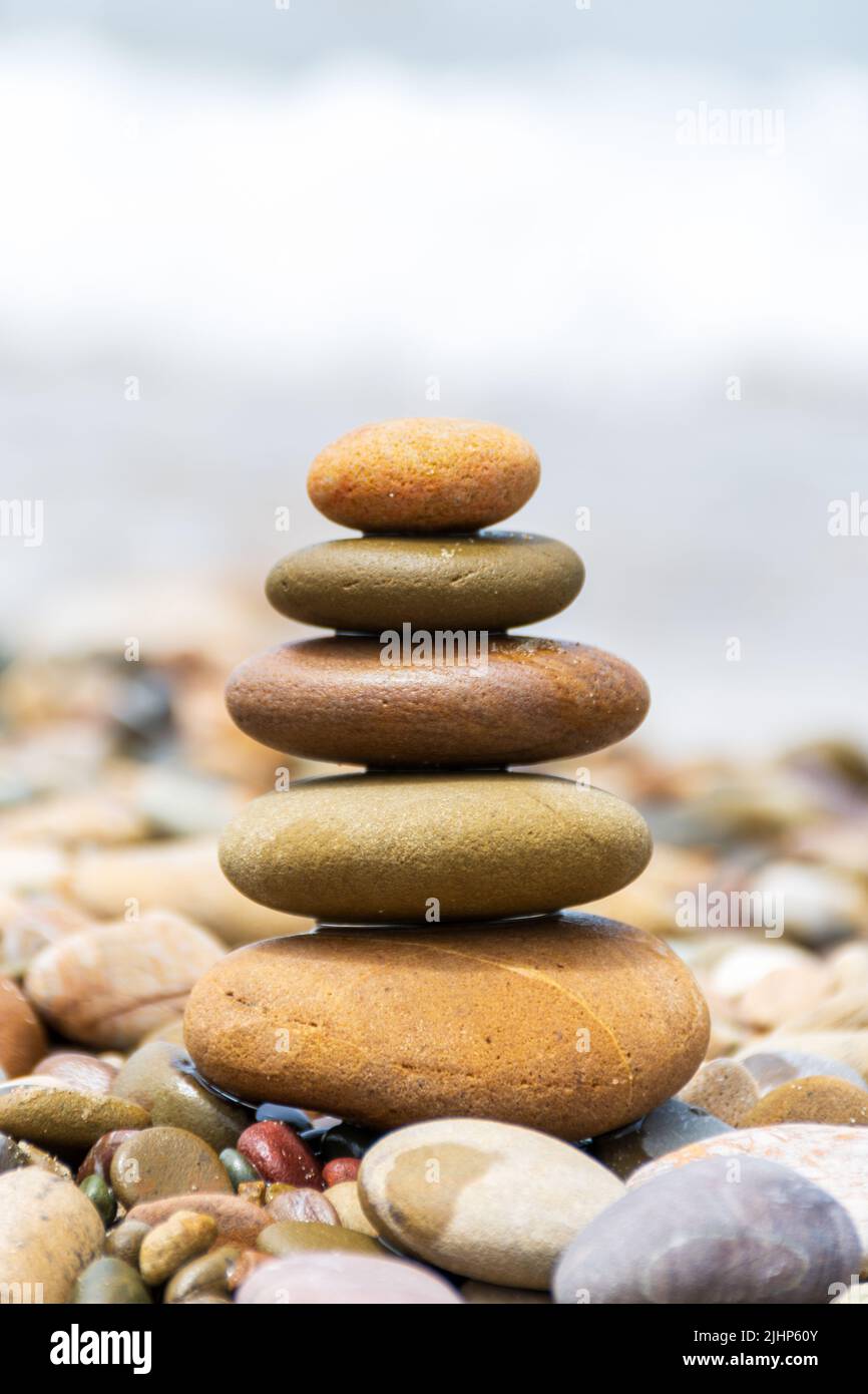 Close-up pyramid stones balance on the beach. Calm. Zen-like concept. Stock Photo