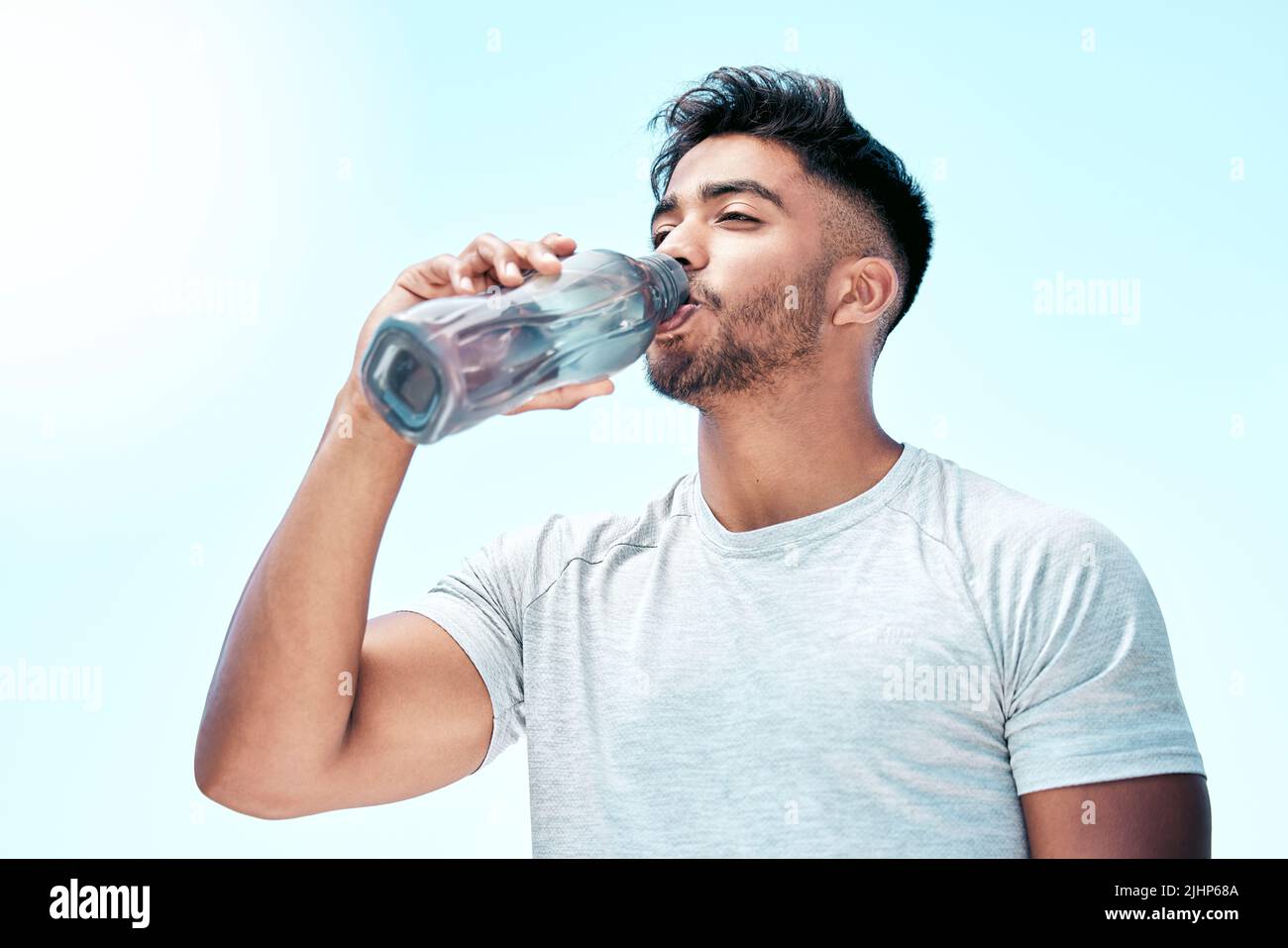 https://c8.alamy.com/comp/2JHP68A/fit-young-mixed-race-man-drinking-water-from-a-bottle-while-exercising-outdoors-handsome-hispanic-male-taking-a-sip-of-water-during-a-break-from-his-2JHP68A.jpg