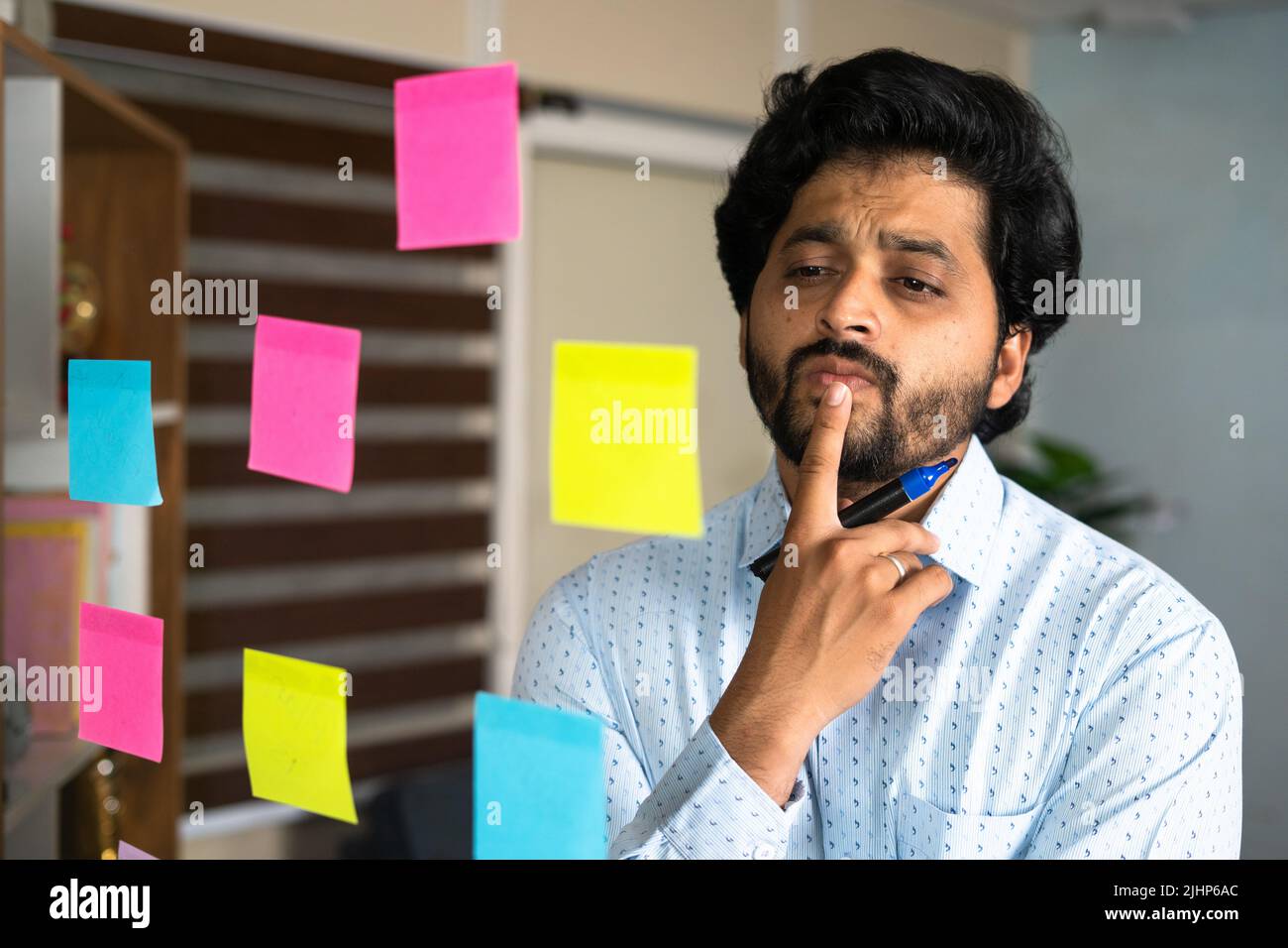 thoughtful young entrepreneur busy planning while working at office - concept of making business strategy, brainstorming and analysis Stock Photo