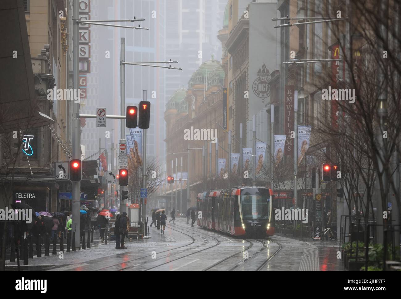 Sydney, Australia - 19 July 2022. A light rail approaches traffic lights on George Street on a gloomy winter's day in downtown Sydney. Stock Photo