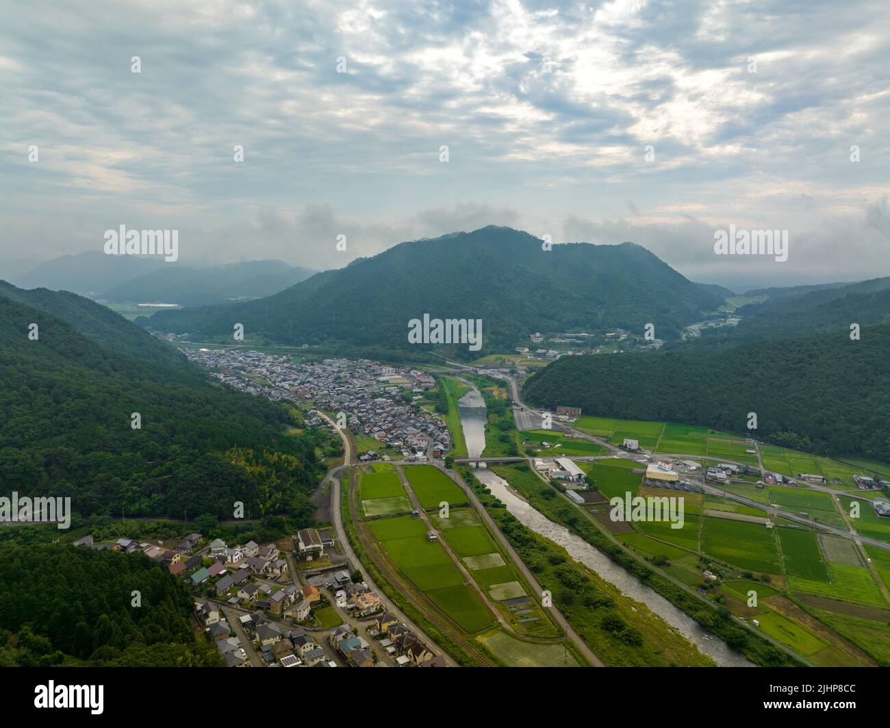 Aerial view of river flowing through small town in valley Stock Photo ...