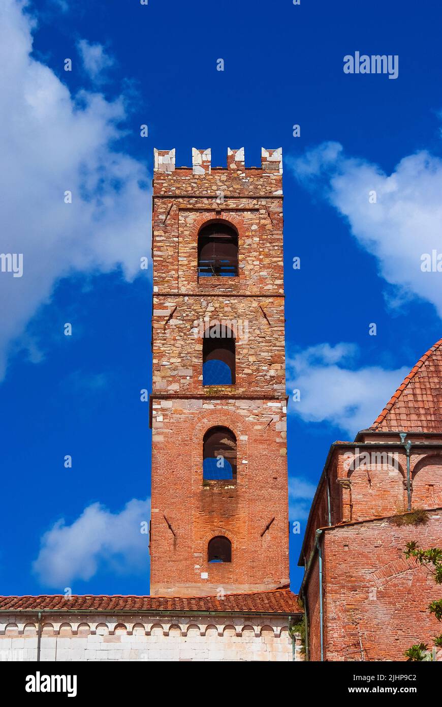 Church of Ss John and Reparata ancient belfry in the shape of medieval tower among clouds Stock Photo