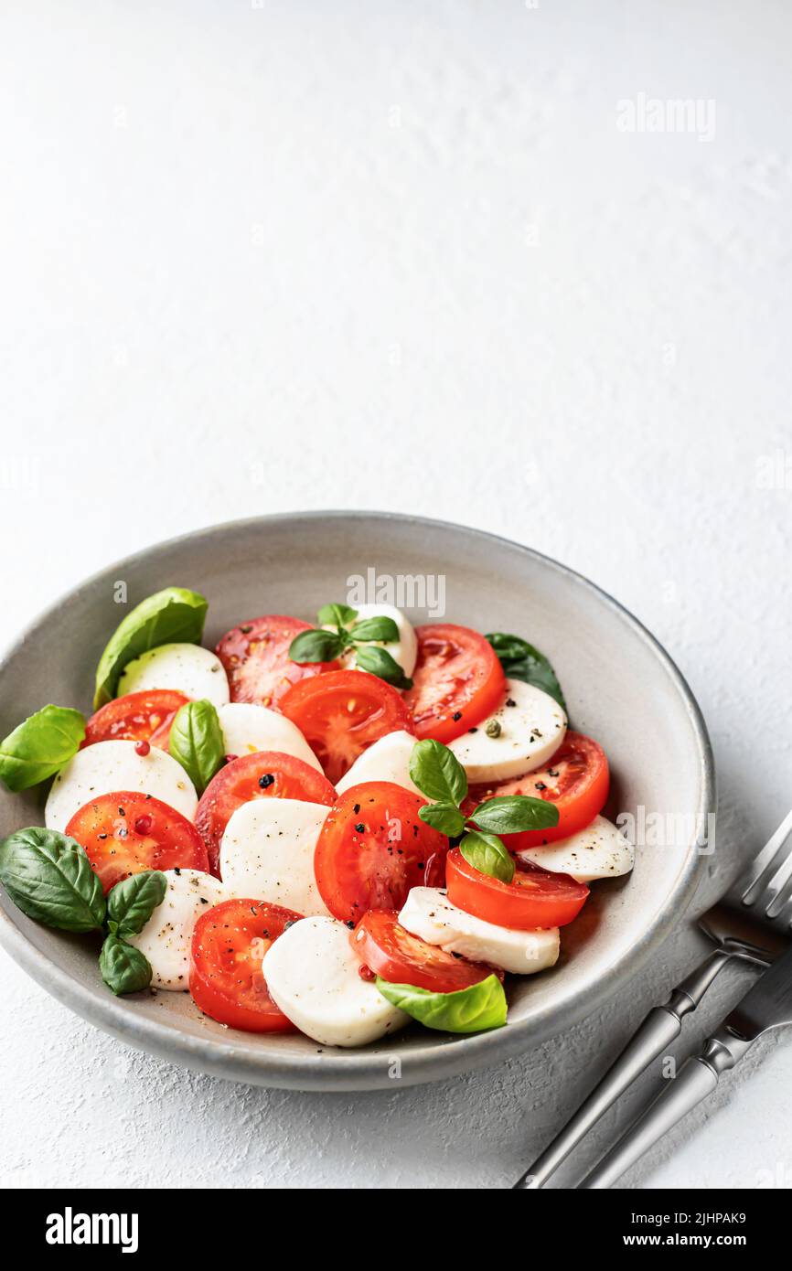 Traditional Italian Caprese salad with tomatoes mozzarella basil and ...