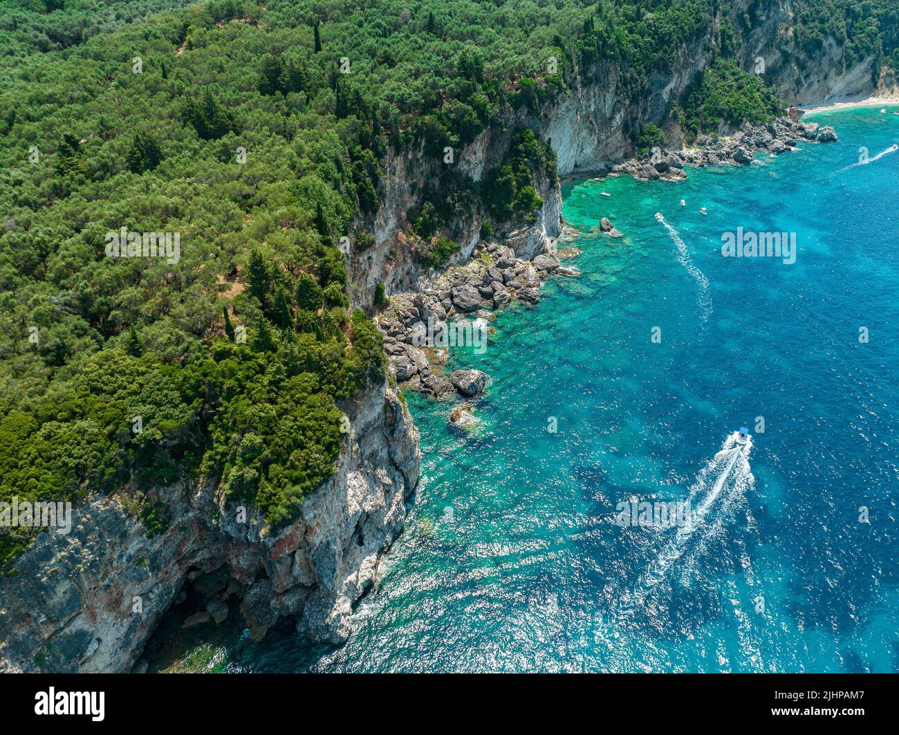 Aerial view of Kolias Beach on the island of Corfu. Greece. Cliffs overlooking the beach and an uncontaminated green and blue sea. Moored boats Stock Photo