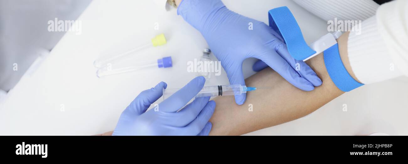 Nurse injects liquid medication in womans vein with needle Stock Photo