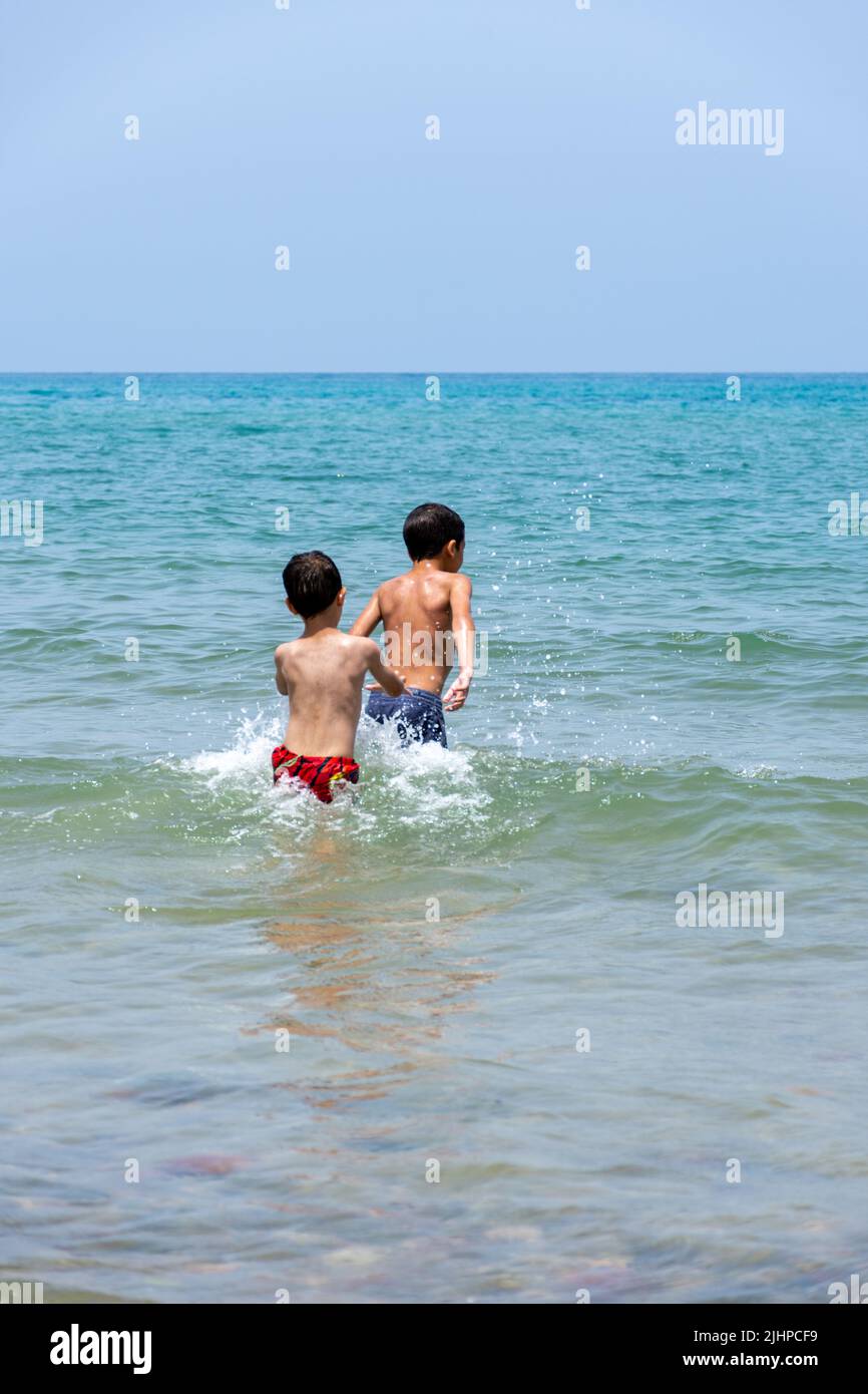 View of young boys playing in the  Mediterranean sea. Summer vacation concept. Stock Photo