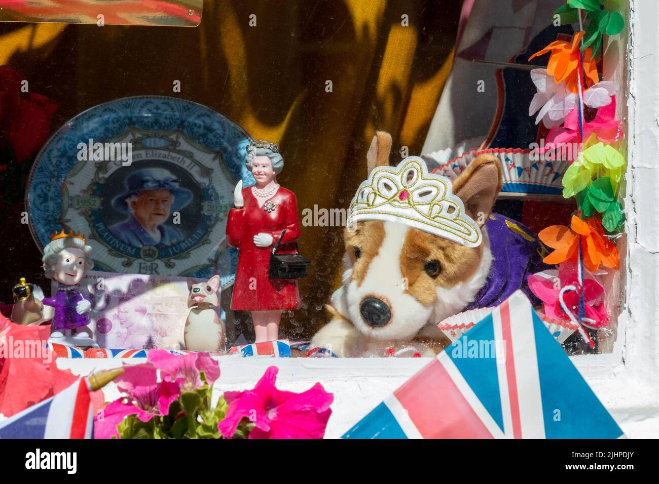 Unofficial decorations for the Platinum Jubilee of Queen Elizabeth II include a waving model queen and a soft toy corgi wearing a tiara. Stock Photo