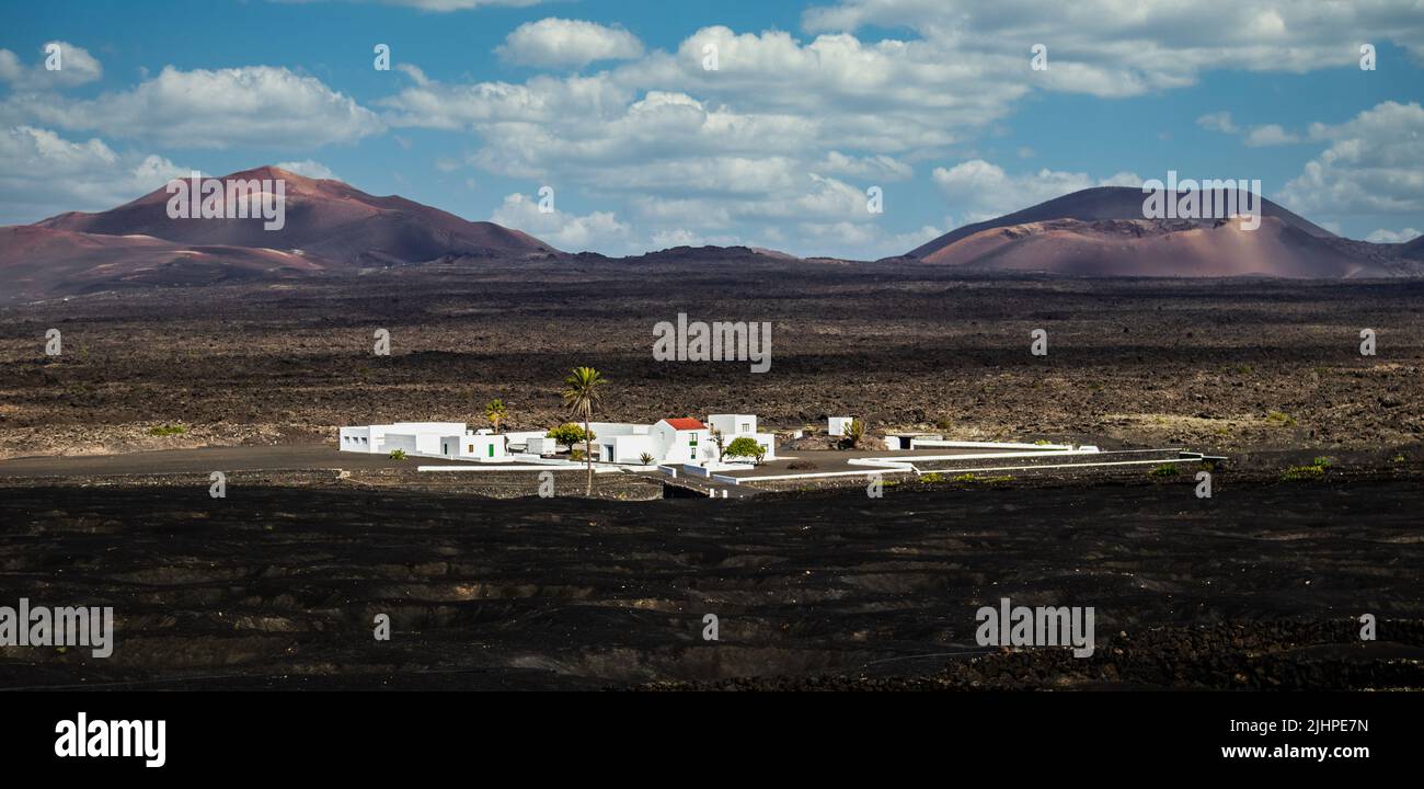 Amazing panoramic landscape of volcano craters in Timanfaya national park. Popular touristic village in La Gueria, Lanzarote island, Canary islans Stock Photo