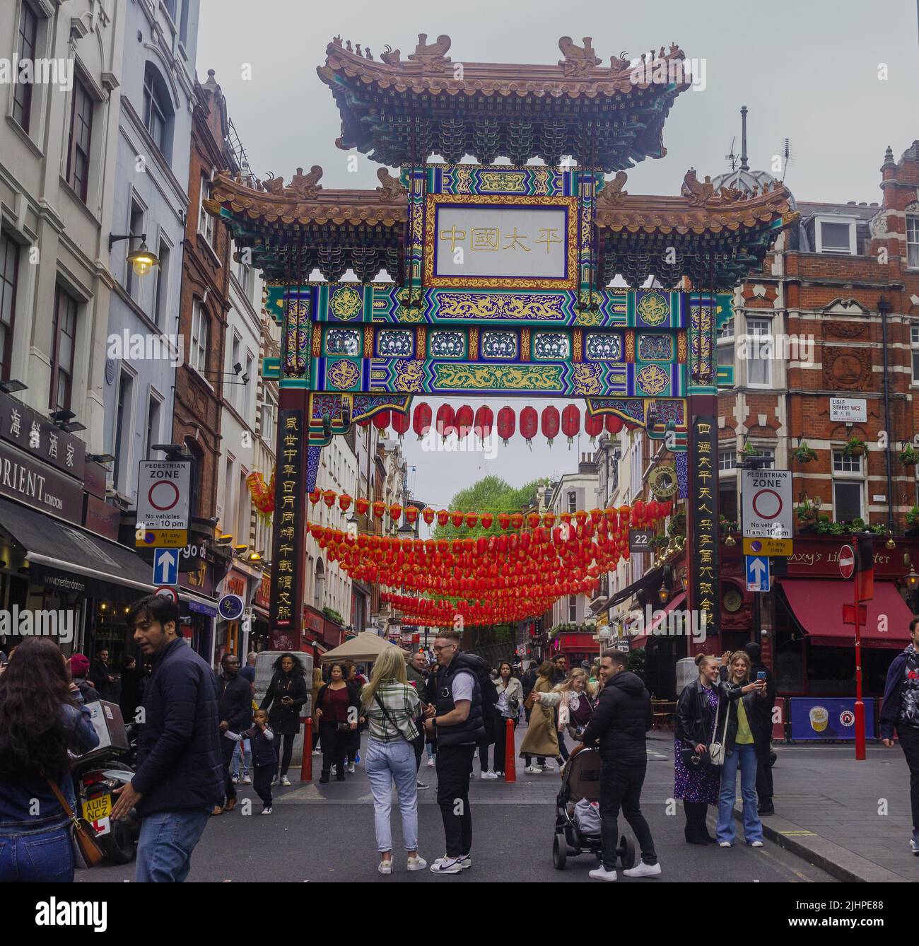 London, UK- May 2022: Chinatown, the entrance gate to Chinatown, crowds of people Stock Photo