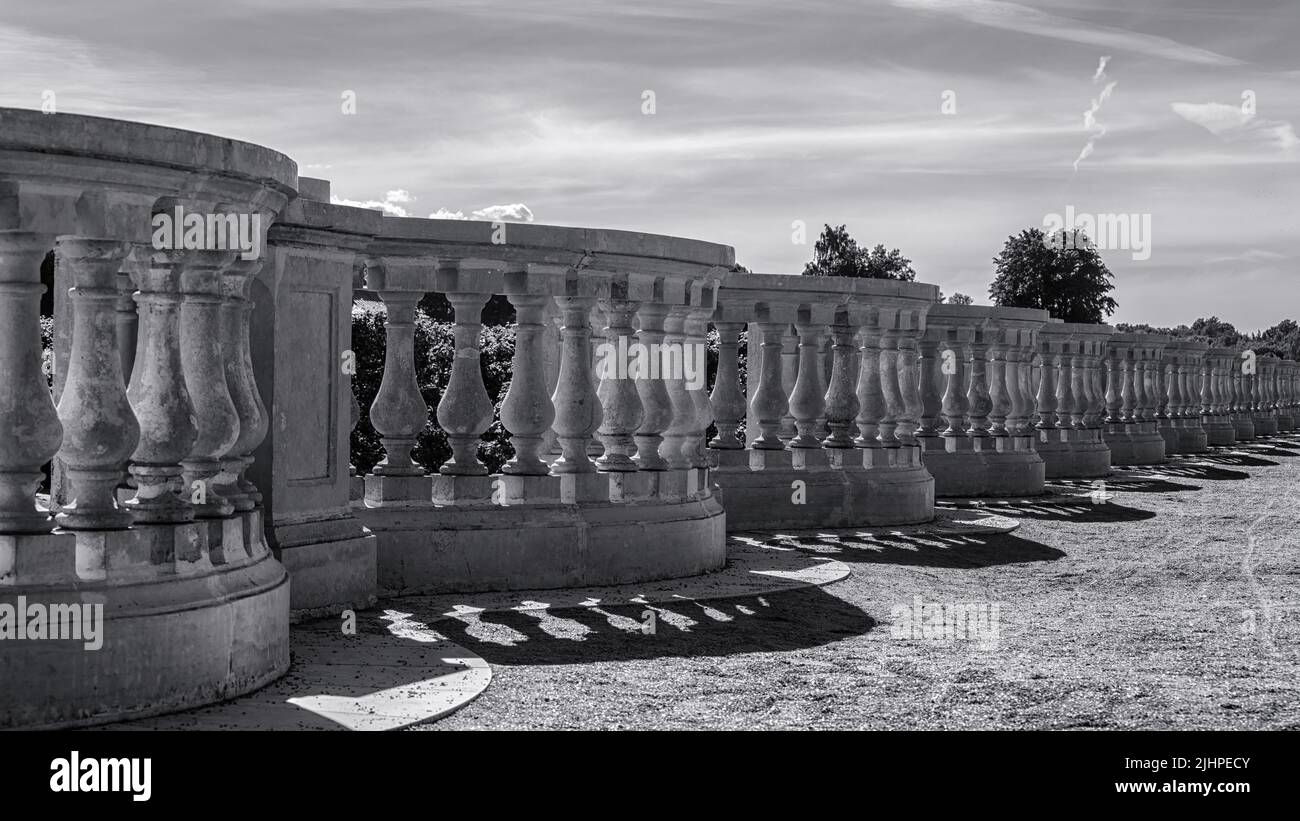 Vintage stone balustrade in the park on a bright sunny day. Artistic black and white photo Stock Photo