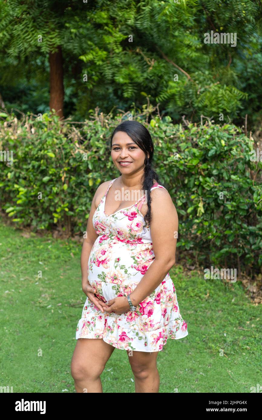 Pregnant Woman Holding Her Belly While Laughing Stock Photo - Alamy