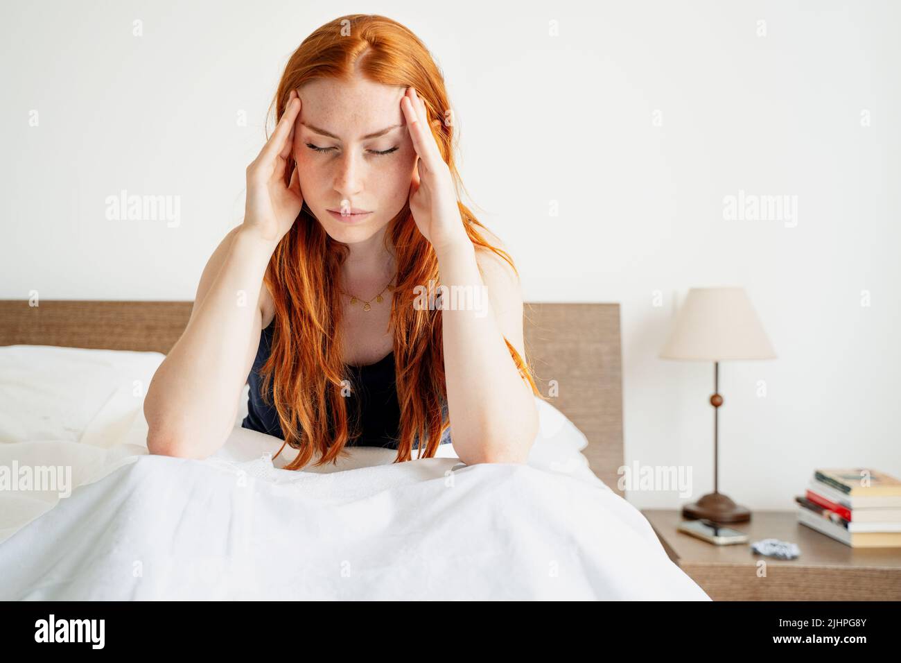 Tired woman lying awake in bed suffer from insomnia headache Stock Photo