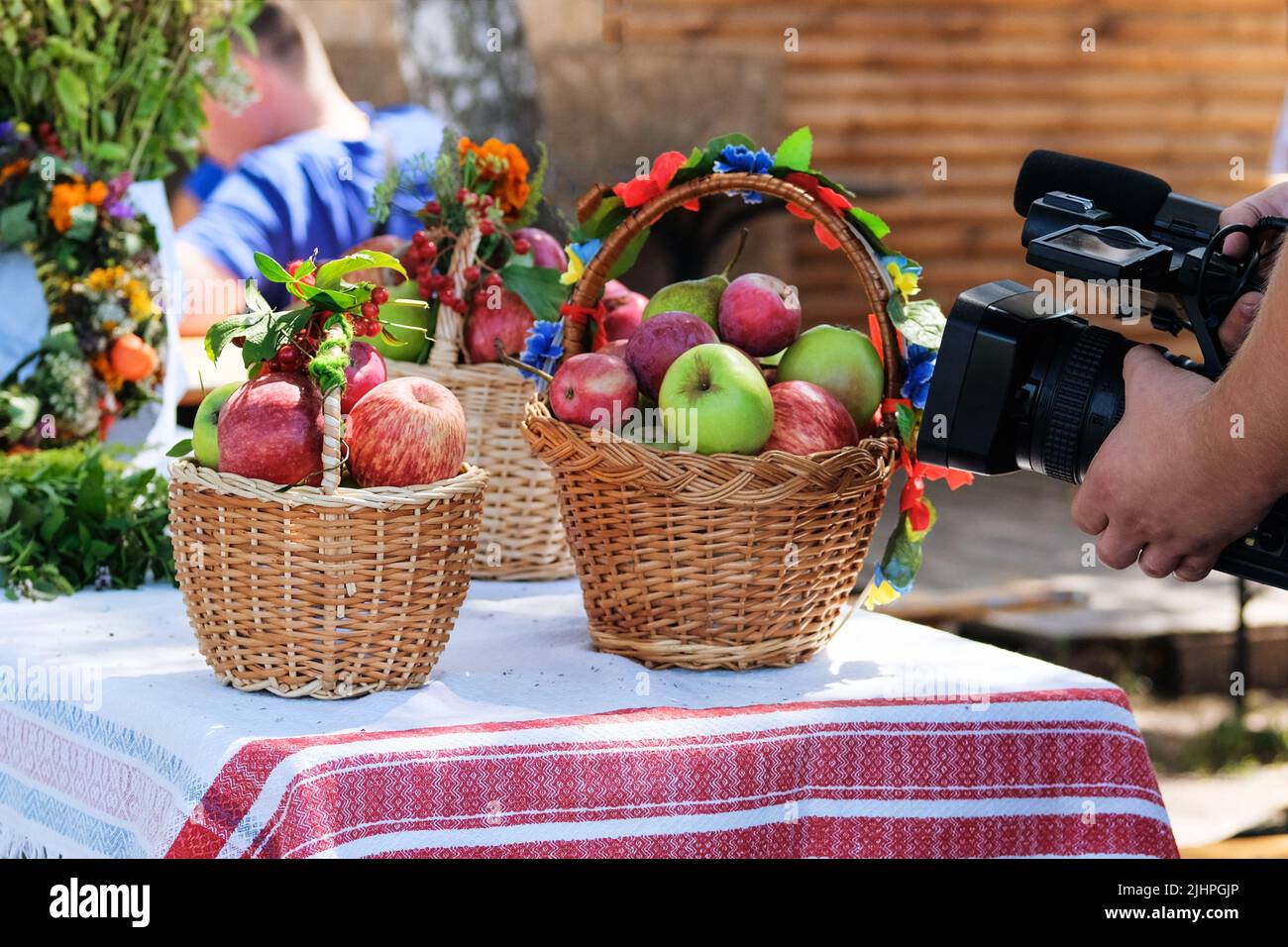Filming a video of apples in wicker baskets in a peasant style. Rural blogging. Stock Photo