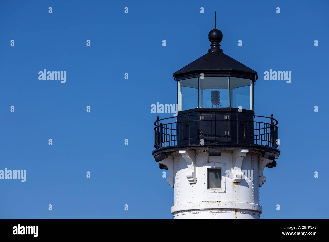 A lighthouse tower with a blue sky background. Stock Photo