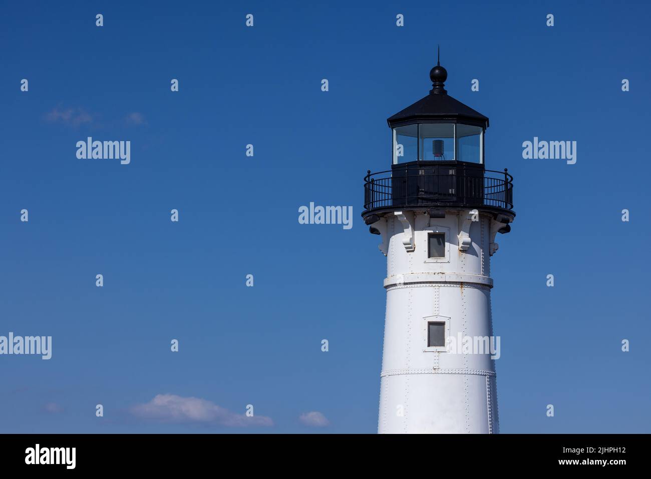 A lighthouse tower with a blue sky background. Stock Photo