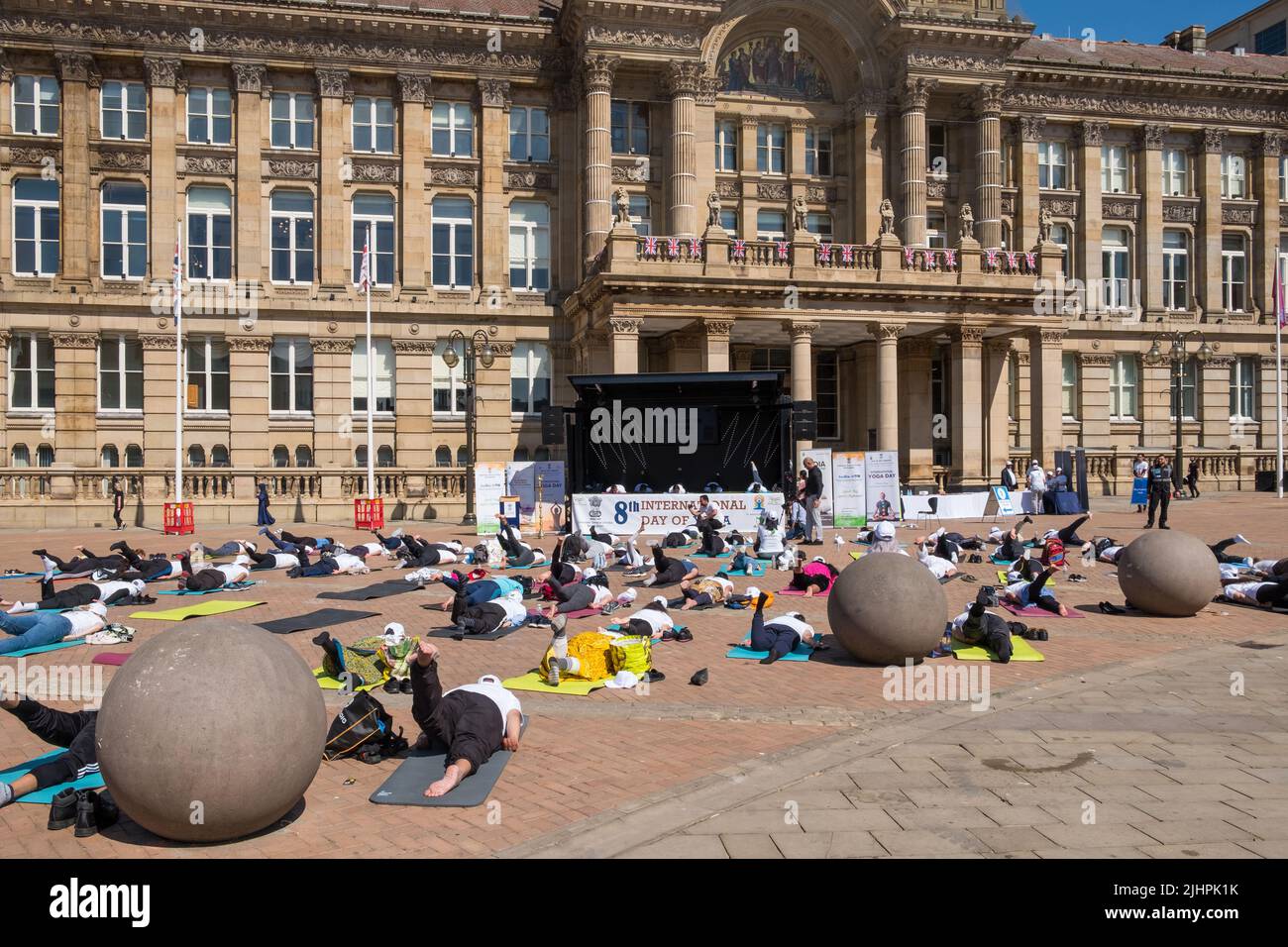 People practising yoga in front of Birmingham Council House in Victoria Square, Birmingham, UK on International Day of Yoga Stock Photo