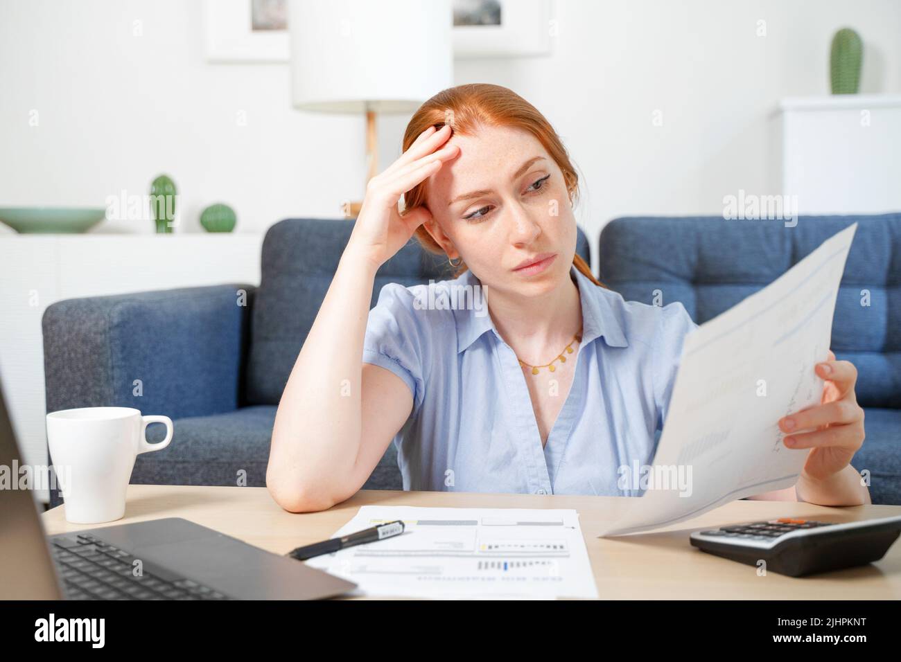Woman working through papers and calculating home budget Stock Photo