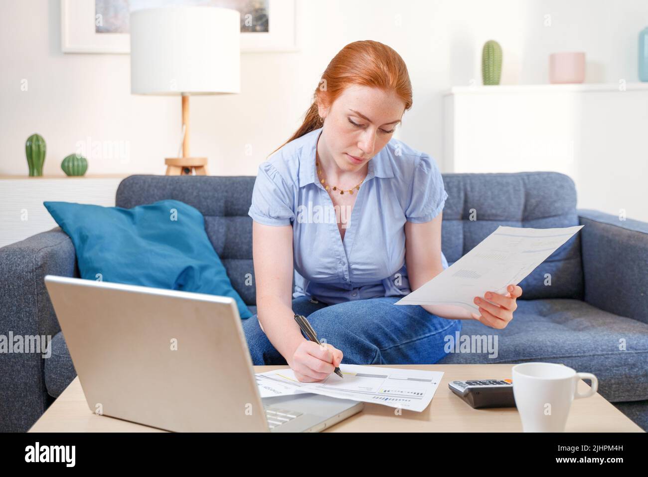 Woman analyzing financial budget with calculator at home Stock Photo