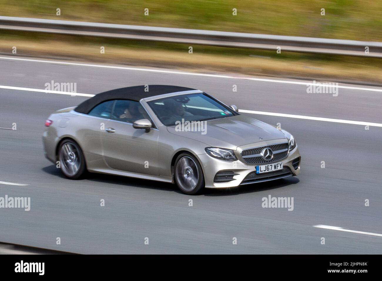 2017 silver Mercedes Benz E cabrio, E 300 Amg Line Premium + Auto E300 9G-Tronic Auto 1991cc 9 speed sequential automatic; travelling on the M6 Motorway, Manchester, UK Stock Photo