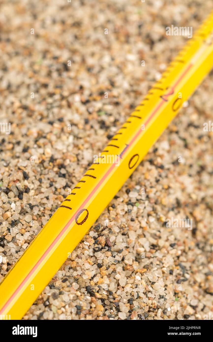 Close shot glass alcohol thermometer on coarse sand. Focus on 0 C. For 2022 Summer heatwave, UK heatwave, hot weather, high temperatures, severe heat. Stock Photo